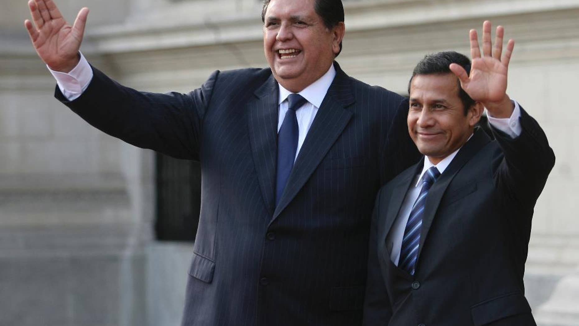 FILE - In this Friday, June 17, 2011 file photo, Peru's outgoing President Alan Garcia, left, and Peru's President-elect Ollanta Humala wave to reporters during a meeting at the government palace in Lima, Peru. Garcia is, as of Monday, Oct. 19, 2015, an official candidate for a third term as Peru's president, with elections due in April. (AP Photo/Marcelo Luna, File)
