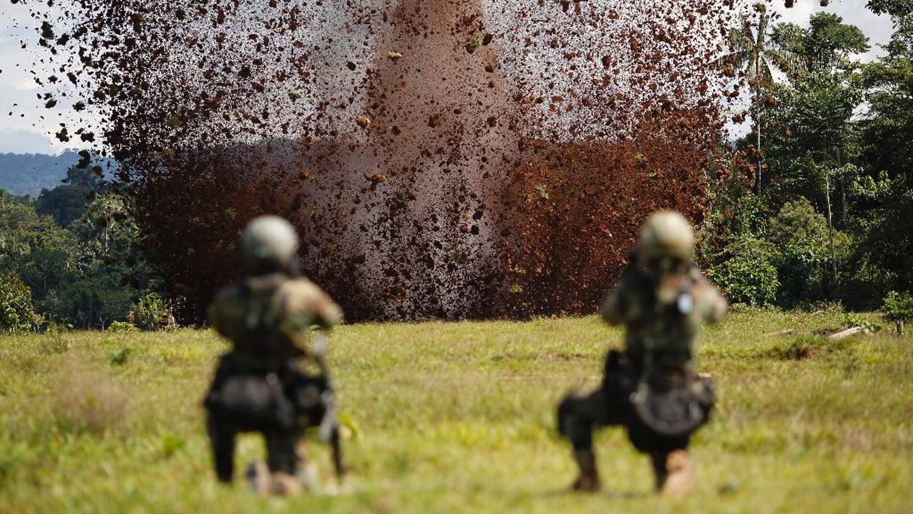 FILE - In this July 28, 2015, file photo, Peruvian counternarcotics police blast a hole in a clandestine airstrip used by cocaine traffickers in Ciudad Constitucion, Peru. Peruvian police arrested an army lieutenant Thursday, Oct. 22, 2015, alleging he regularly collected bribes from drug traffickers for letting small planes ferry cocaine out of the world's No. 1 coca-producing valley. The arrest was Peru's first of a military officer on drug trafficking charges in at least a decade, said Jorge Chavez Cotrina, Peru's chief organized crime prosecutor. (AP Photo/Rodrigo Abd, File)