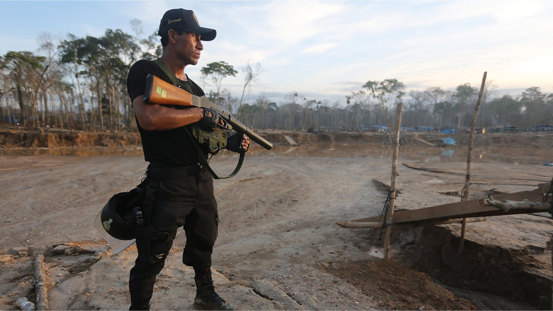 MADRE DE DIOS REGION, PERU - NOVEMBER 17: A National Police officer searches an illegal mining operation in the Amazon lowlands on November 17, 2013 in Madre de Dios region, Peru. Police eventually destroyed three pieces of illegal mining equipment in the area. The biologically diverse Madre de Dios ('Mother of God') region has seen deforestation from gold mining in the area triple since 2008, when gold prices spiked during global economic turmoil. Small-scale miners are drawn to the area in hopes for higher pay but often face abysmal conditions. Gold is usually amalgamated with mercury during the process of informal mining in the region, which is discharged into the water supply and air, poisoning fish and sickening people in the area. Peru is the largest producer of gold in Latin America and the sixth-largest in the world. Informal mining accounts for roughly 20 percent of the gold production in Peru. (Photo by Mario Tama/Getty Images)