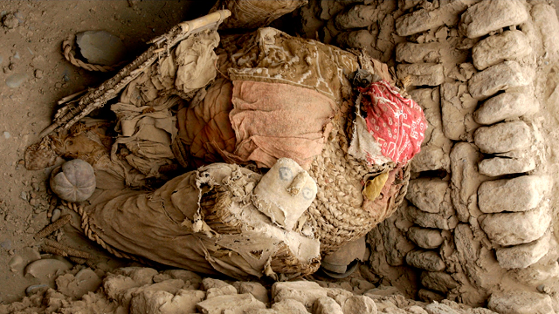 Three funerary bales from the Wari culture, the one at center of an adult and the two at the sides of children, sit inside a tomb discovered at a pyramid called Huaca Pucllana in Lima, Peru, Wednesday, Oct. 20, 2010. A team of Peruvian archaeologists have unearthed what they say are four 1,160-year old mummies from the Wari culture in the heart of Lima.