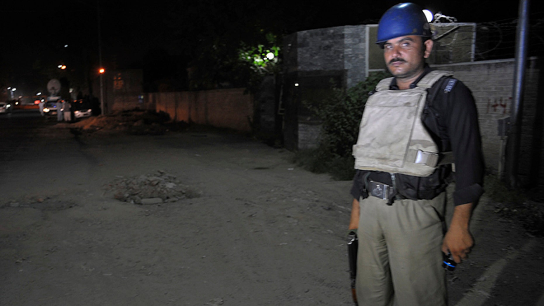 June 25, 2014: A Pakistani police officer stands guard near Peshawar airport which is cordoned off, in Pakistan. Authorities in Pakistan were looking for a gunman who opened fire at a plane Tuesday evening just as it was landing in the volatile northwest, killing one person and wounding two others, officials said, casting fresh doubts about security at the country's airports.