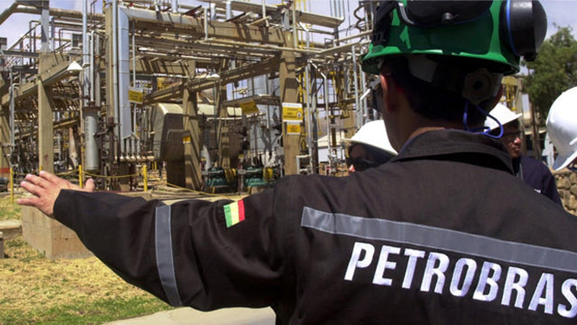 A Bolivian employee of Brazil's oil giant Petrobras subsidiary Petrobras Bolivia shows a natural gas facility at the Gualberto Villarroel , 8m (about 5 miles) south of Cochabamba, Bolivia, Tuesday, Sept. 5, 2006. The nationalization of Bolivia's hydrocarbons industry took two steps forward this week as the government opened long-awaited contract negotiations with foreign petroleum companies while collecting the first round of higher royalties it now charges those firms. Representatives of the French company Total S.A. sat down with Hydrocarbons Ministry officials Tuesday in La Paz to begin drawing up a new contract ceding a majority share of their Bolivian operations to the government, as required by President Evo Morales' May 1 nationalization decree. Contract negotiations with other international firms _ including Brazil's state-owned Petrobras and the Spanish-Argentine firm Repsol YPF _ are expected to follow.(AP Photo/Nano Cartagena)