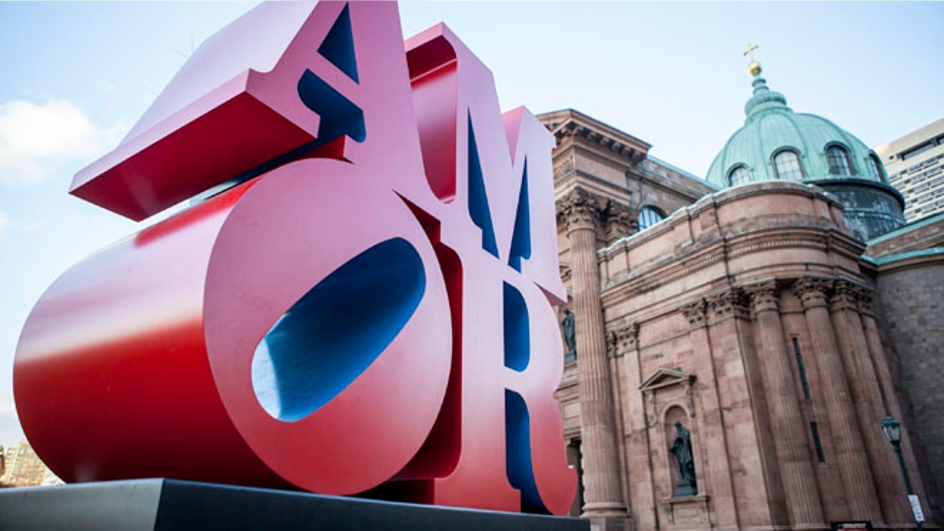 This photo shows Robert Indiana's AMOR sculpture in a park outside Philadelphia's Cathedral Basilica of Saints Peter and Paul, Friday, Dec. 2, 2016. Officials say the sculpture, originally loaned to Philadelphia for last year's papal visit, will permanently remain in the city. It's a Spanish and Latin version of Indiana's LOVE sculpture, which is a Philadelphia landmark. (AP Photo/Michael R. Sisak)