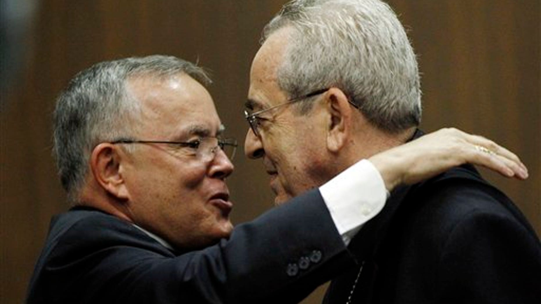 July 19: Denver Archbishop Charles Chaput, left, and Cardinal Justin Rigali embrace during a news conference in Philadelphia.