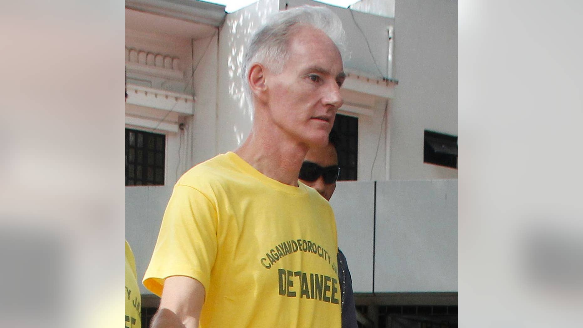 Peter Gerald Scully of Australia walks in handcuffs as he arrives at Cagayan de Oro city hall in southern Philippines on Tuesday, June 16, 2015. Scully and his Filipino girlfriend Carme Ann Alvarez have pleaded not guilty to charges of raping and trafficking two girls aged 9 and 12 in a southern Philippine city. (AP Photo)