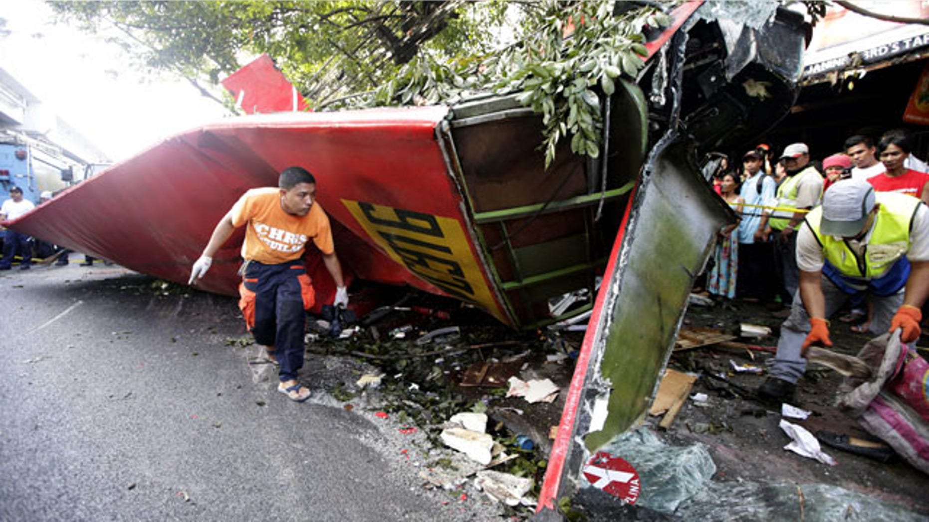 December 16, 2013: Investigators collect items from the wreckage of a passenger bus which plunged from an elevated highway known as the Skyway in suburban Paranaque southeast of Manila, Philippines.