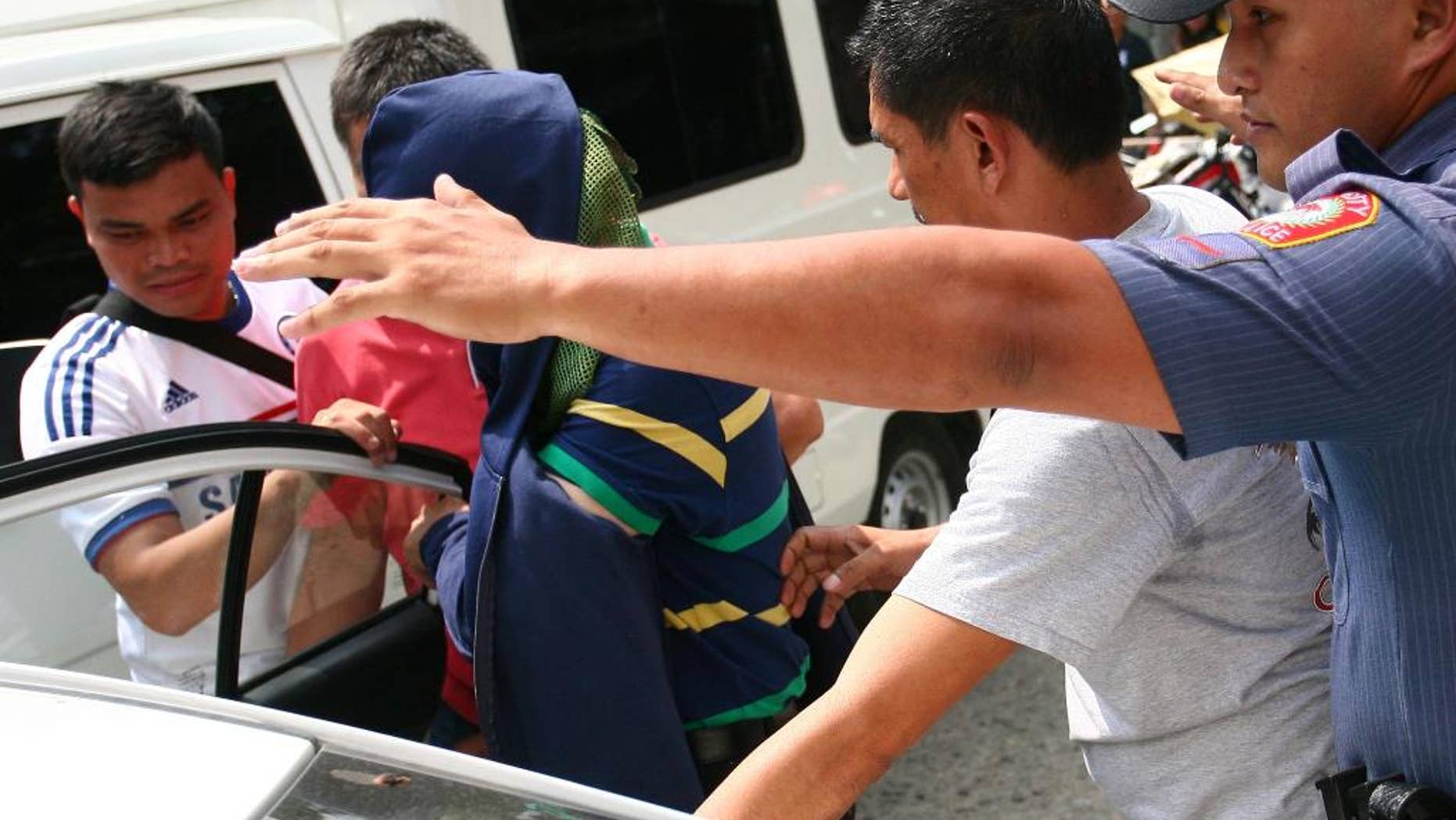 In this photo taken Friday, Oct. 23, 2015, police escort a Chinese man, allegedly the husband of a Chinese consul who is a suspect in the fatal shooting of two Chinese diplomats and the wounding of the consul-general, prior to being deported back to China from Cebu city in central Philippines. On Saturday, Oct. 24, Foreign Affairs spokesman Charles Jose said, a Chinese consular officer and her husband, who allegedly killed two other Chinese diplomats and wounded their consul-general in a Philippine city, have been taken back to China where they will be tried. (AP Photo)