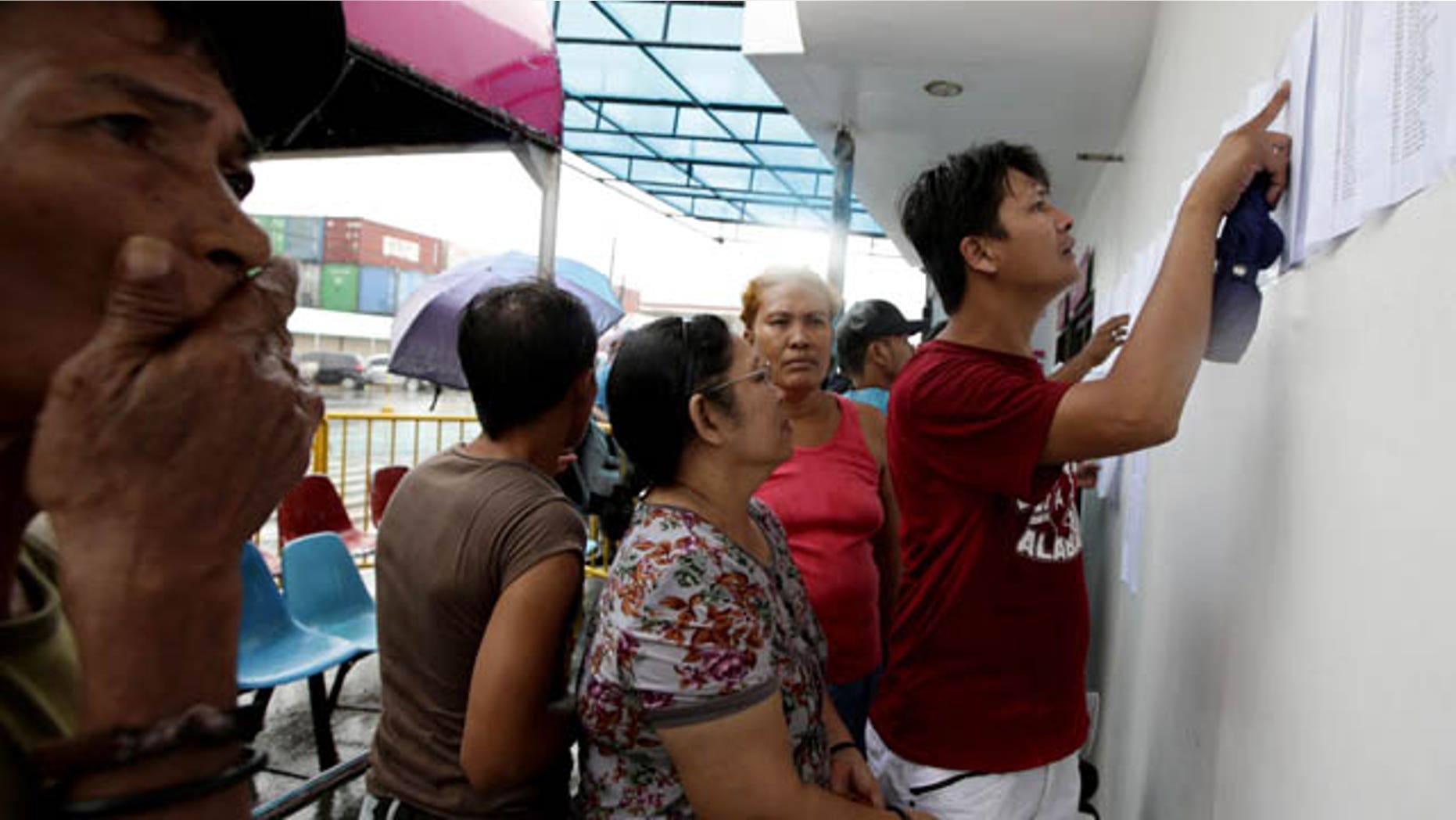 August 17, 2013: Relatives check the lists of survivors and the still-missing passengers and crew of the ill-fated passenger ferry MV Thomas Aquinas, outside the ticketing office of a shipping company. (AP Photo)