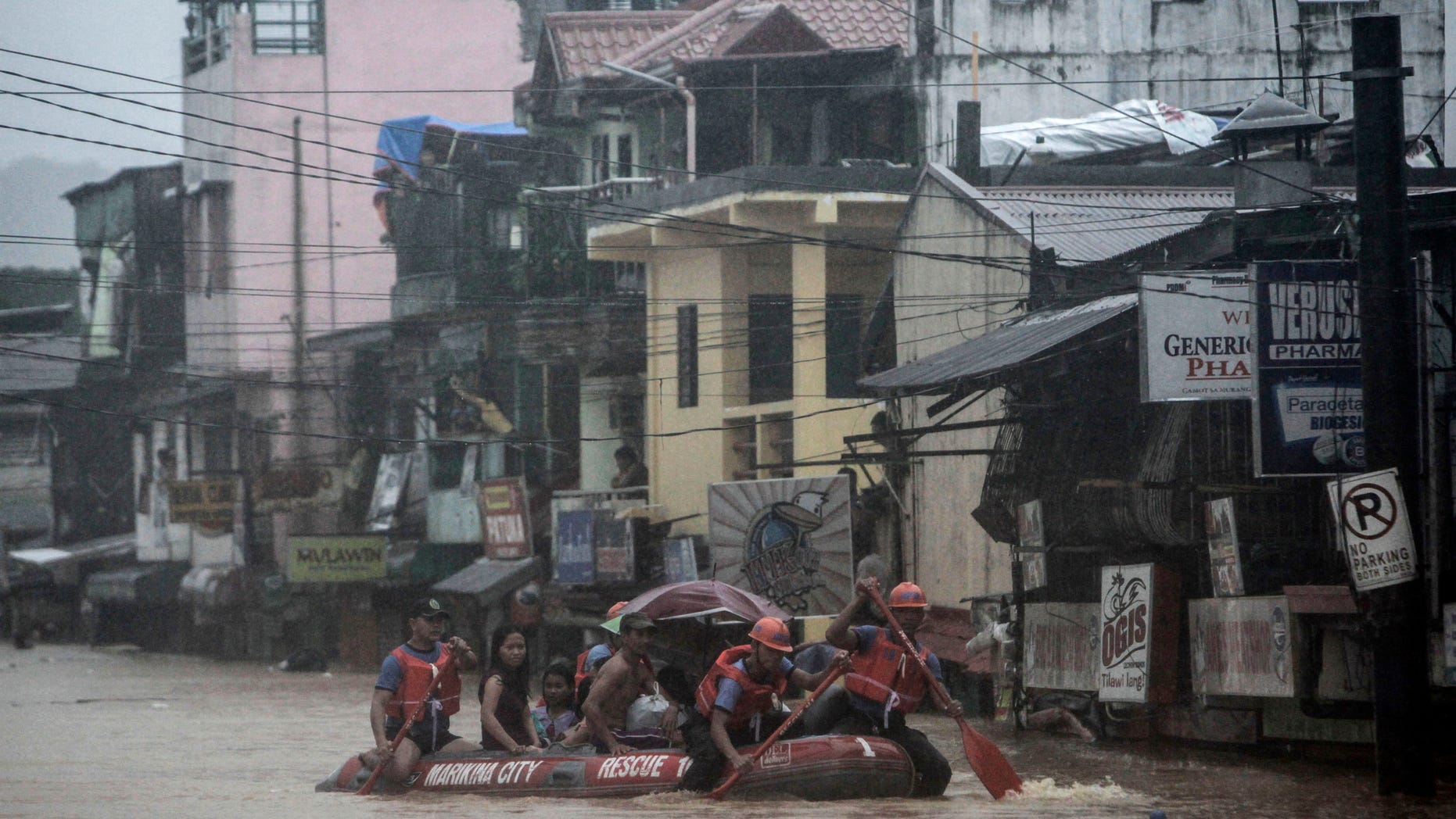 Aug. 7, 2012: Rescuers paddle to higher grounds as they evacuate residents in Marikina, east of Manila, Philippines.
