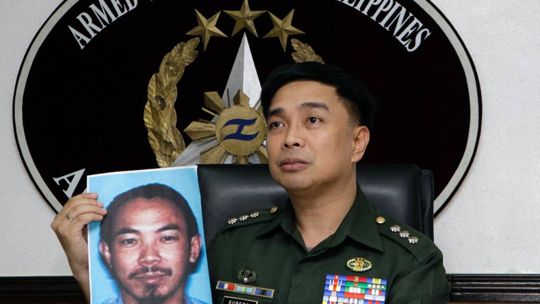 FILE - In this Feb. 2, 2012 file photo, then Armed Forces of the Philippines spokesman Col. Marcelo Burgos shows a picture of Malaysian Zulkifli bin Hir, also known as Marwan, during a press conference in suburban Quezon City, north of Manila, Philippines. Southeast Asia's top terrorist suspect has evaded capture and survived several military assaults in the southern Philippines, where police now await DNA results to confirm if he is the man killed in the Jan. 25, 2015 raid that also left 44 police commandos dead. (AP Photo/Pat Roque, File)