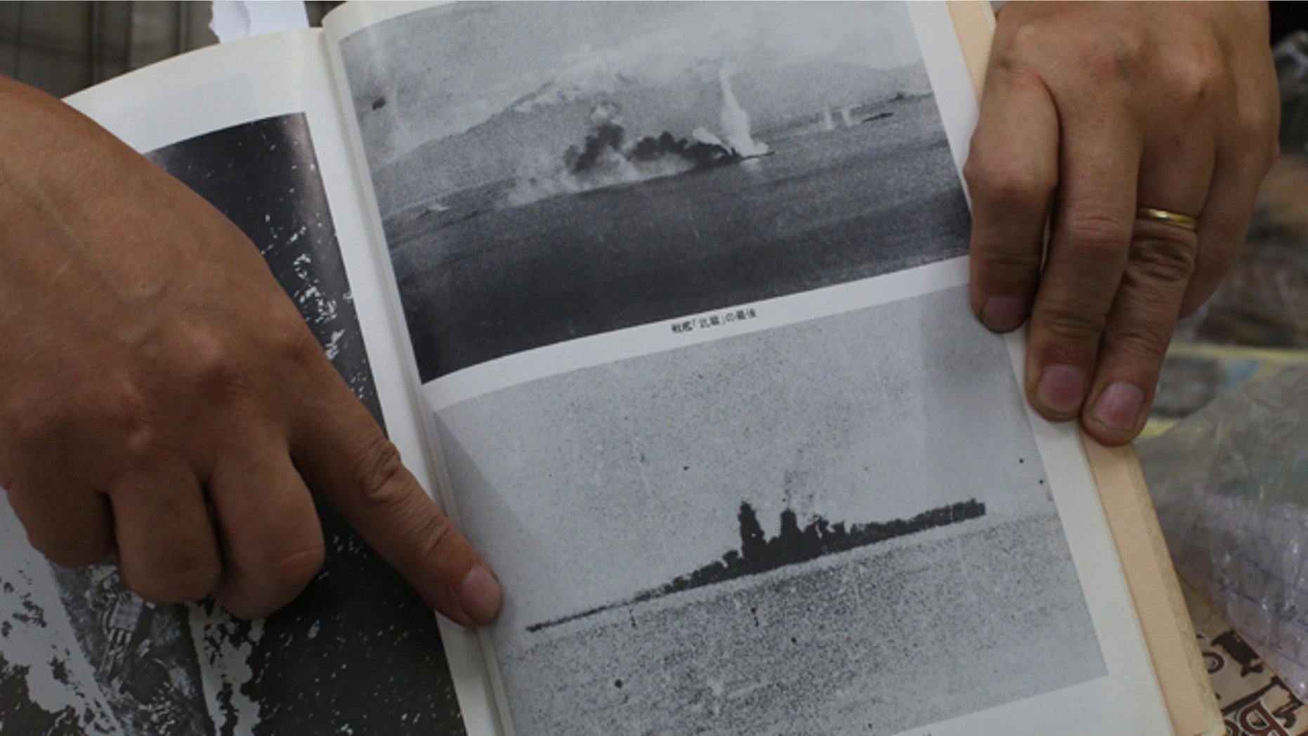 March 5, 2015: Filipino World War II historian Professor Rico Jose shows pictures before the Japanese World War II battleship Musashi sank as he talks to reporters at his office in suburban Quezon city, north of Manila. (AP Photo/Aaron Favila)