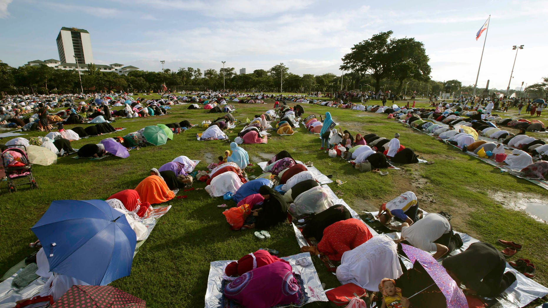 July 28, 2014 - Filipino Muslims gather at Manila's Rizal Park to pray in celebration of Eid al-Fitr marking the end of the holy month of Ramadan, in Manila, Philippines. Abu Sayyaf gunmen killed at least 21 villagers, including women and children, traveling to visit relatives and celebrate the end of Ramadan, military officials said.