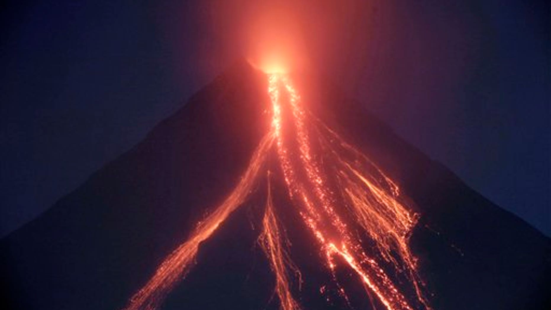 Lava cascades down the slopes of Mayon volcano in a continuing mild eruption as viewed from Legazpi city, Albay province, about 500 kilometers southeast of Manila, Philippines at dusk on Christmas eve Thursday Dec.24, 2009. Volcanologists warned that the weeklong moderate eruption of the 8,070-foot (2,460-meter) Mayon could escalate within days as the volcano belched out 20 grayish ash columns Thursday, some a mile (1.5 kilometers) high.