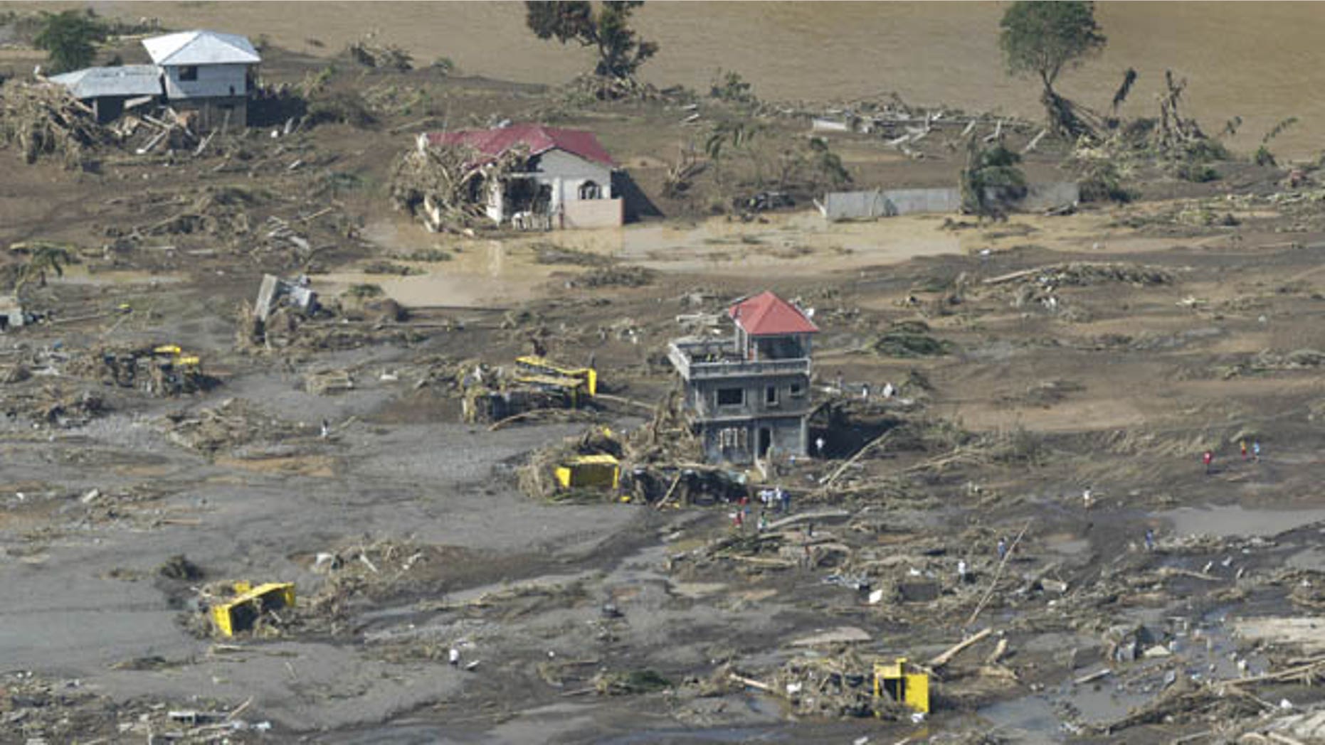 December 18, 2011: Remains of destroyed houses, toppled trucks and uprooted trees lie along a flood-hit area in Cagayan de Oro city, southern Philippines.