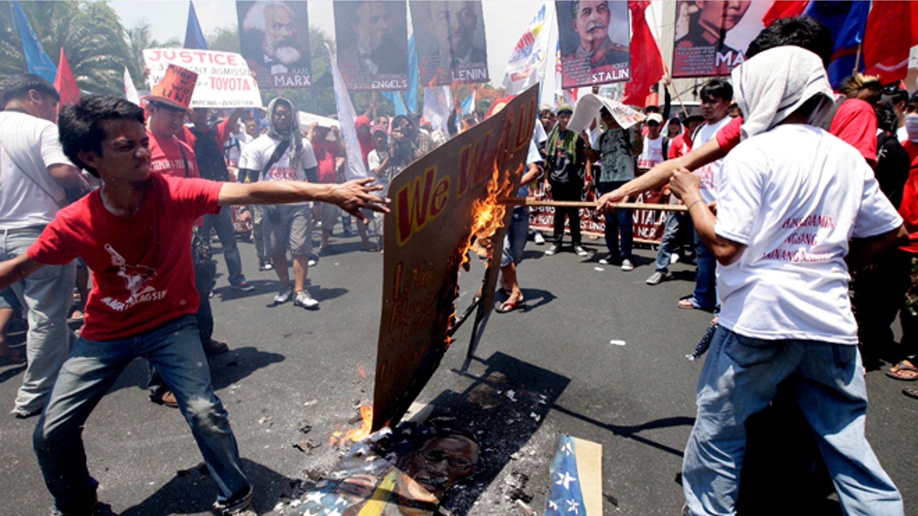 May 1, 2013: Protesters, mostly workers, burn a mural depicting U.S. President Barack Obama and Philippine President Benigno Aquino III after being blocked by police from getting closer to the U.S. Embassy in Manila to mark International Labor Day in Manila, Philippines. The workers, who have demanding wage increases for years, assailed Aquino for his Labor Day "gift" of non-wage benefits.
