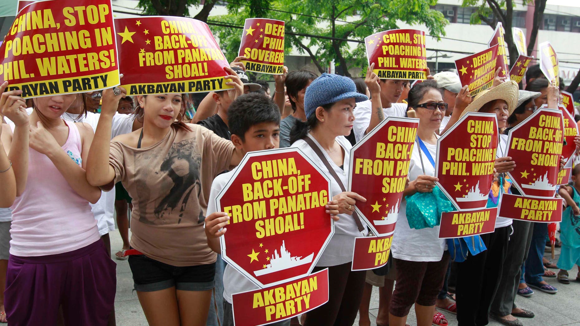 April 16, 2012: Protesters display placards during their rally outside the Chinese Consulate at the financial district of Makati city, east of Manila, Philippines, to accuse poaching by Chinese fishermen that led to a military standoff at the disputed Scarborough Shoal in the South China Sea. The Philippine president said Monday his country will continue talks with China to resolve the impasse, which began last Tuesday when two Chinese ships prevented a Philippine warship from arresting several Chinese fishermen.