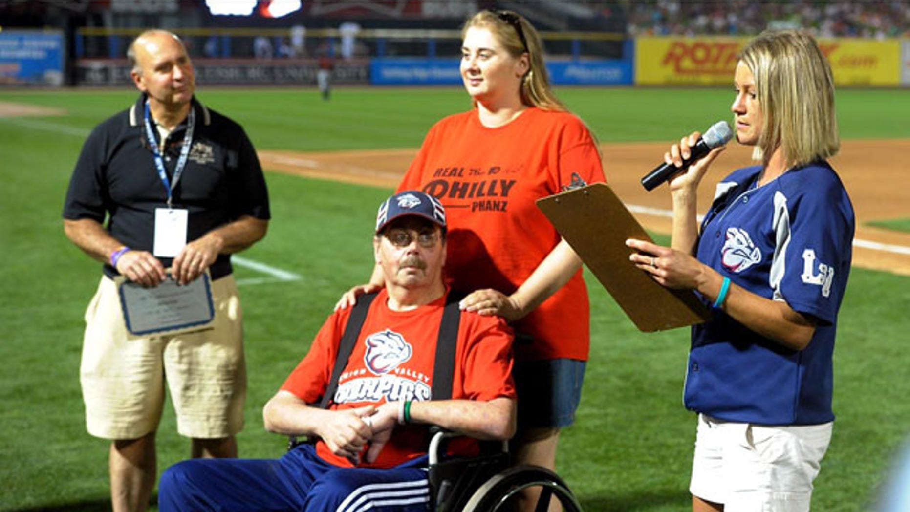 August 20, 2013: Kevin Reichel, left, of Reichel Funeral Home, watches along with Steve Paul, of Freemansburg Pa., and his daughter Robyn Paul as Lindsey Knupp, right, director of promotions and entertainment for the Lehigh Valley Iron Pigs minor league baseball team, reads the winning essay written by Steve Paul during the middile of the sixth inning at Coca-Cola Park, in Allentown, Pa. (AP Photo)