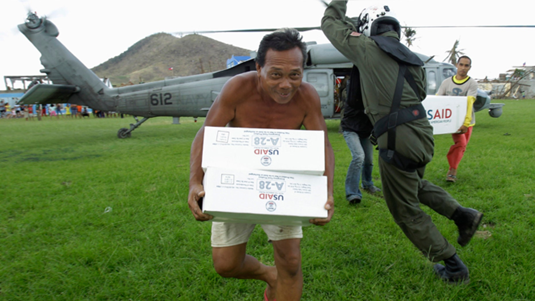Nov. 20: U.S. Navy Aviation ASW Operator Third Class Caleb Rausch, of Durham, North Carolina, dodges typhoon victims carrying aid from a U.S. Navy Seahawk helicopter in Palo, Philippines.