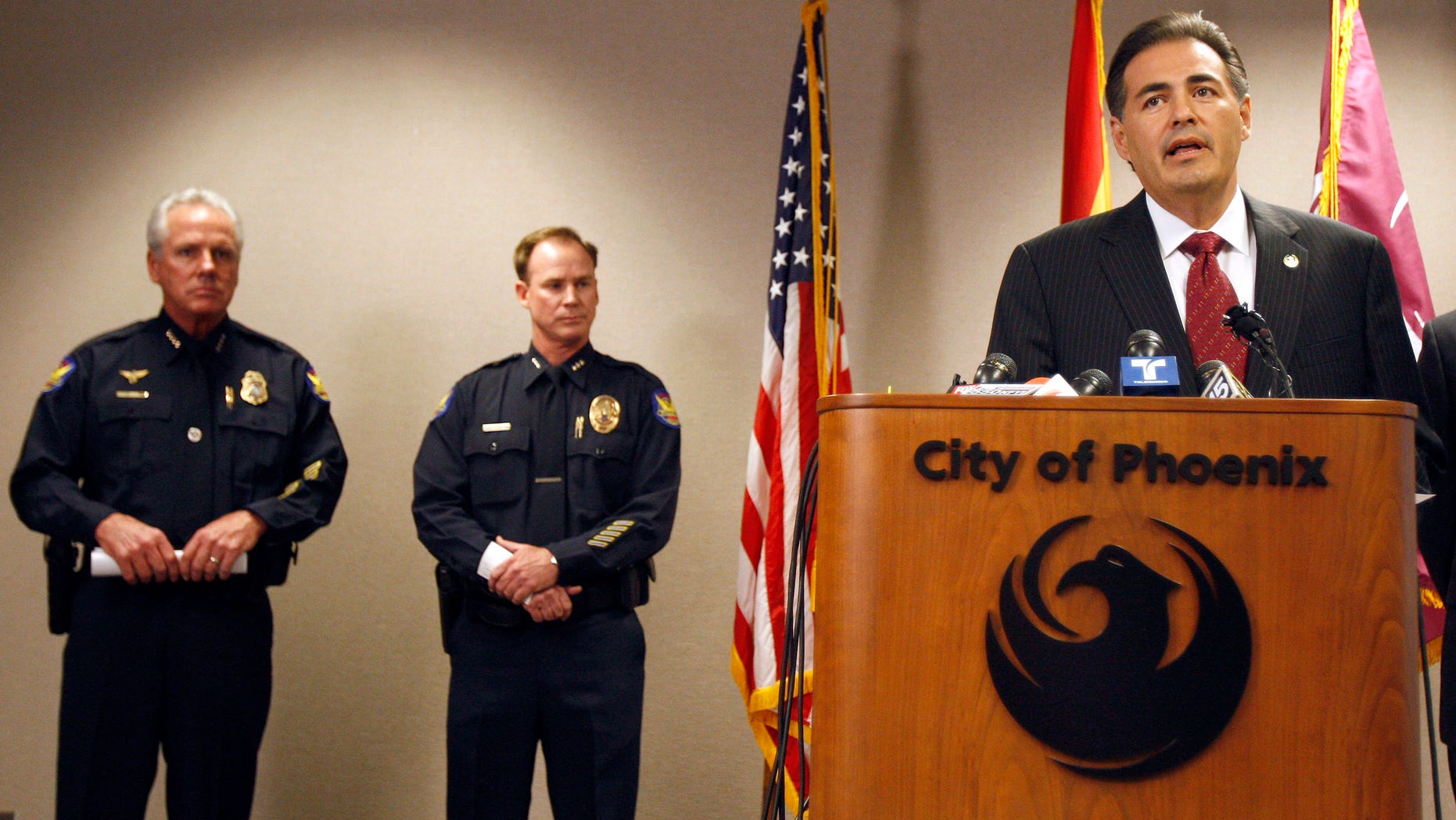 Phoenix Police Chief Jack Harris, left, listens during a news conference as Phoenix City Manager David Cavazos, right, talks about the shakeups announced in the police hierarchy at City Hall March 3 in Phoenix.