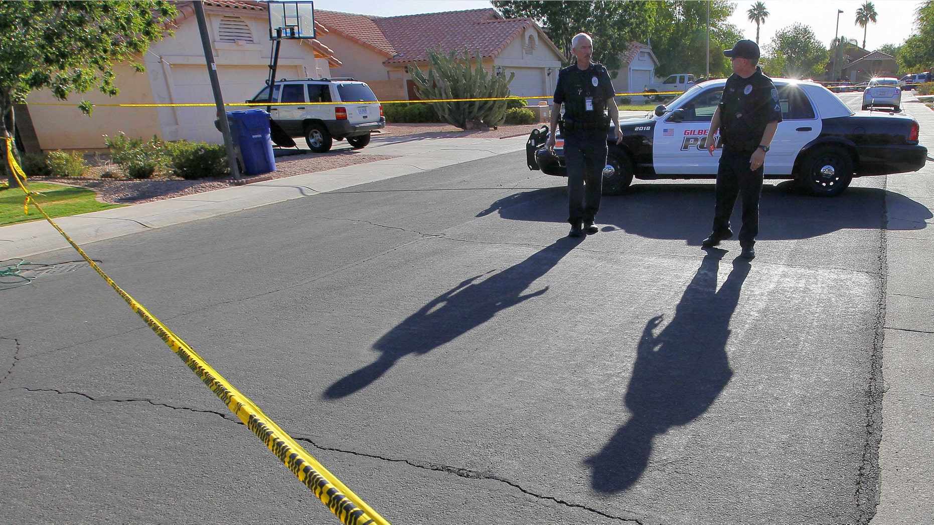 Gilbert police officers blocks the street outside a shooting crime scene Thursday, May 3, 2012 in Gilbert, Ariz. Gilbert police spokesman Sgt. Bill Balafas said Thursday that police believe Jason Todd Ready, 39, a former Marine with ties to neo-Nazi and Minutemen groups, shot four people Wednesday and then took his own life in a suburban Phoenix home. (AP Photo/Matt York)