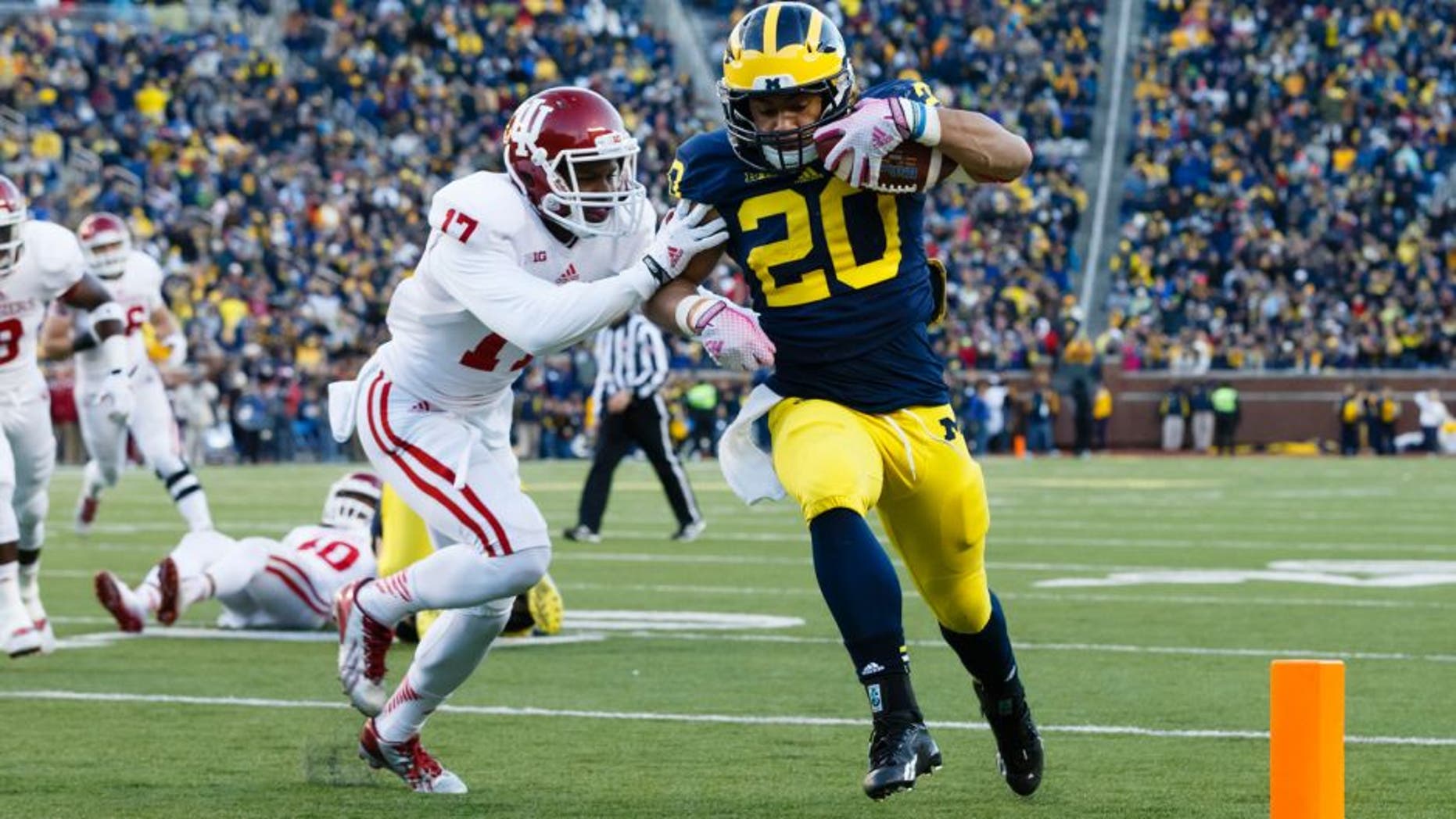 Nov 1, 2014; Ann Arbor, MI, USA; Michigan Wolverines running back Drake Johnson (20) duns the ball in for a touchdown Indiana Hoosiers cornerback Michael Hunter (17) attempts to tackle in the third quarter at Michigan Stadium. Mandatory Credit: Rick Osentoski-USA TODAY Sports