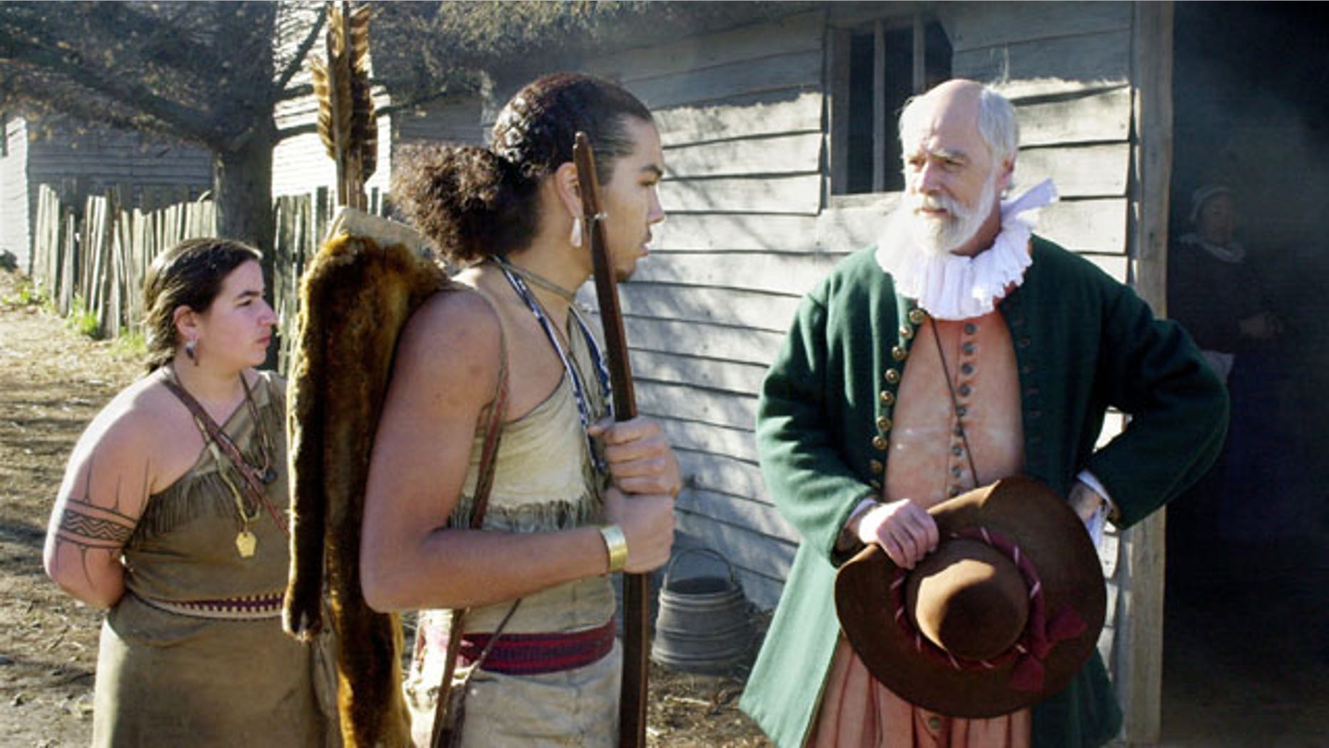 PLYMOUTH, MA - NOVEMBER 25: John Kemp (R) portrays pilgrim Steven Hopkins meeting with the colonists Wampanoag Indian interpreter Hobbamock, played by Jonathan Perry (C), as another Wampanoag, played by Melanie Roderick (L), looks on November 25, 2003 at Plimoth Plantation in Plymouth, Massachusetts. In real life, parents have the difficult job of teaching their children about the truth about what led to the holiday. (Photo by Michael Springer/Getty Images)