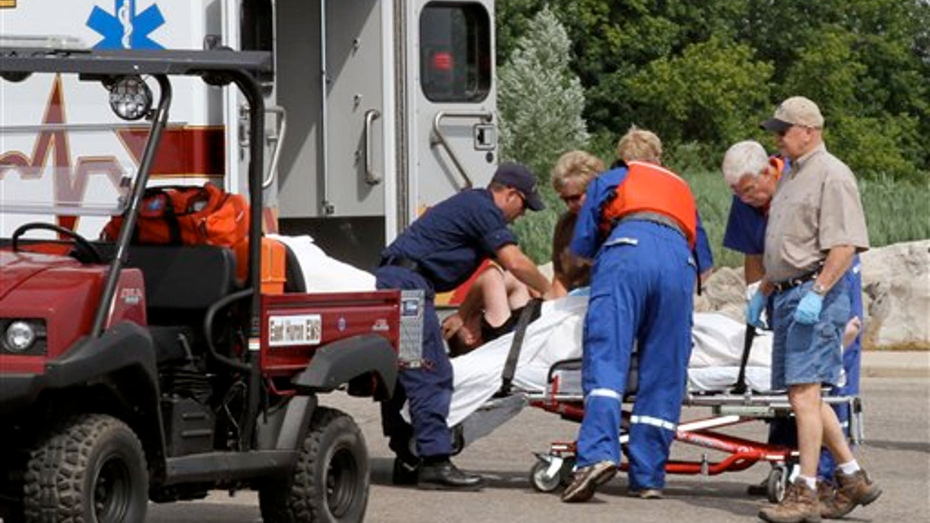 July 27: Pilot Michael W. Trapp, of Gouveneur, NY is placed into an ambulance in Harbor Beach, Mich.