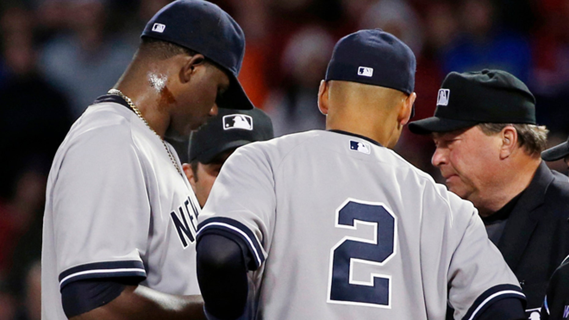Home plate umpire Gerry Davis, right, confers on the mound with New York Yankees starting pitcher Michael Pineda, left; shortstop Derek Jeter (2); and others in the second inning of a baseball game against the Boston Red Sox at Fenway Park in Boston, Wednesday, April 23, 2014. Pineda was ejected after umpires found with a foreign substance on his neck.(AP Photo/Elise Amendola)