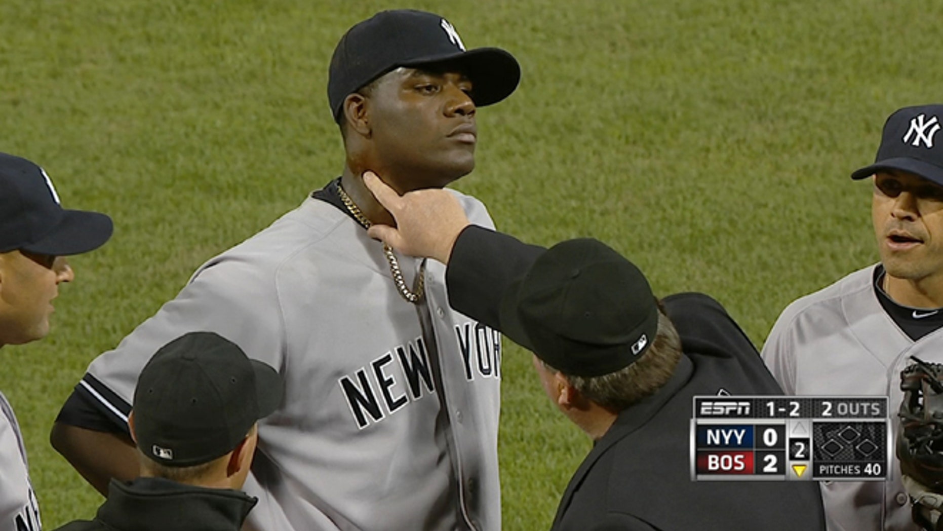 In this April 23, 2014 photo taken from video and provided by ESPN, home plate umpire Gerry Davis touches the neck of New York Yankees starting pitcher Michael Pineda in the second inning of the Yankees' baseball game against the Boston Red Sox at Fenway Park in Boston. Pineda was ejected after umpires found a foreign substance on his neck. (AP Photo/ESPN)