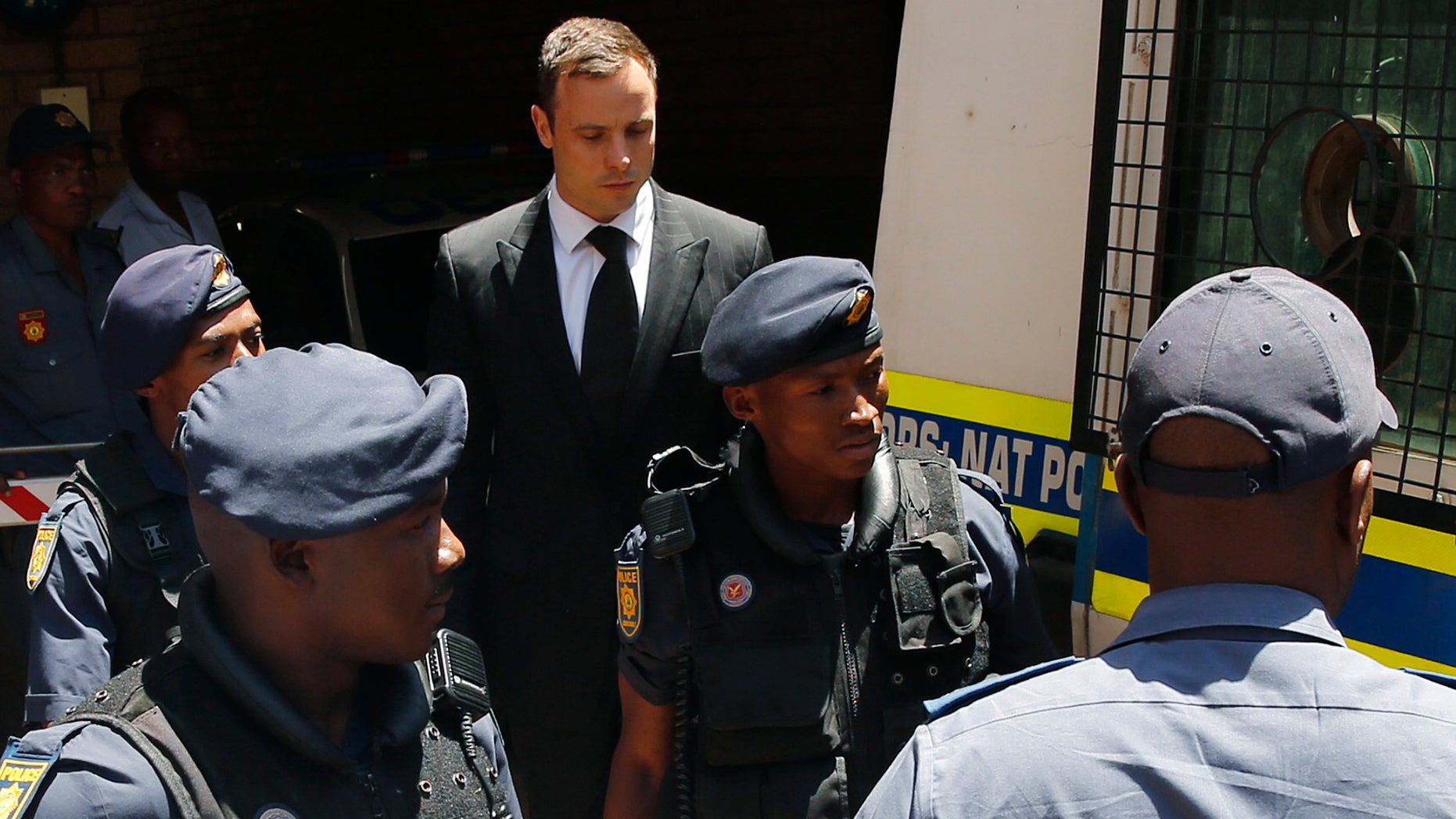 October 21, 2014 - South African Olympic and Paralympic sprinter Oscar Pistorius is escorted to a police van after his sentencing in Pretoria.