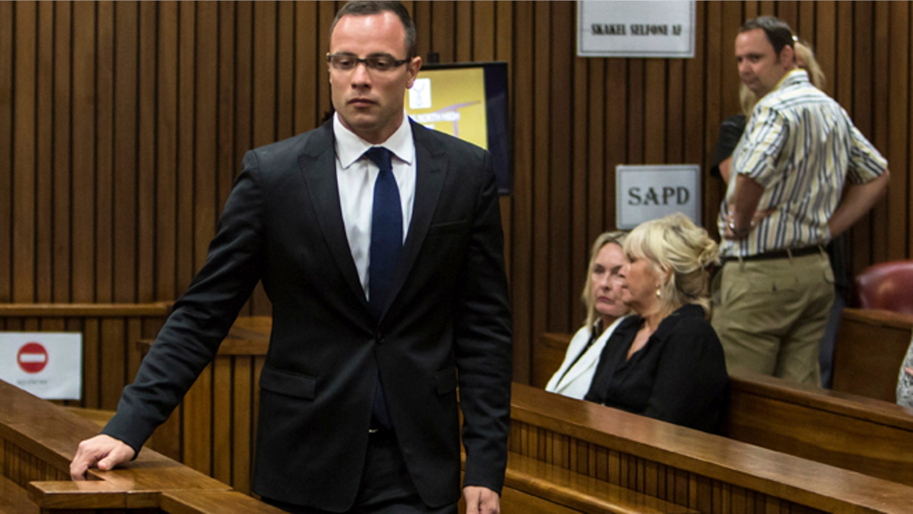 March 17, 2014: Oscar Pistorius, left, walks past June Steenkamp, back left, mother of Reeva Steenkamp, and Jenny Strydom, as he arrives in court in Pretoria, South Africa.