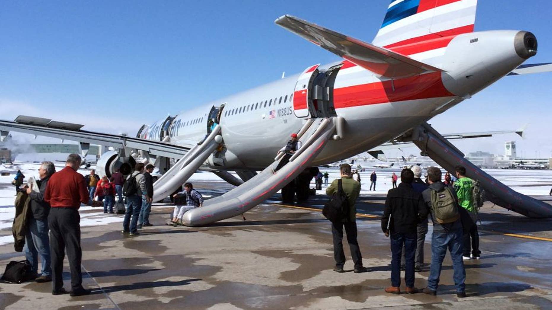 In this photo provided by Andy Long passengers slide down emergency chutes after an American Airlines flight from Charlotte, N.C., soon after landing in Denver, Wednesday, March 4, 2015. The plane, operated by U.S. Airways, was taxiing to the gate at Denver International Airport when smoke was reported in the aircraft just before noon, airport spokeswoman Mindy Crane said. The captain ordered that the chutes be activated, and the passengers and crew members slid down to safety from Flight 445 before being taken by bus to the concourse, said Crane and American Airlines spokeswoman Andrea Huguely. (AP Photo/Andy Long)