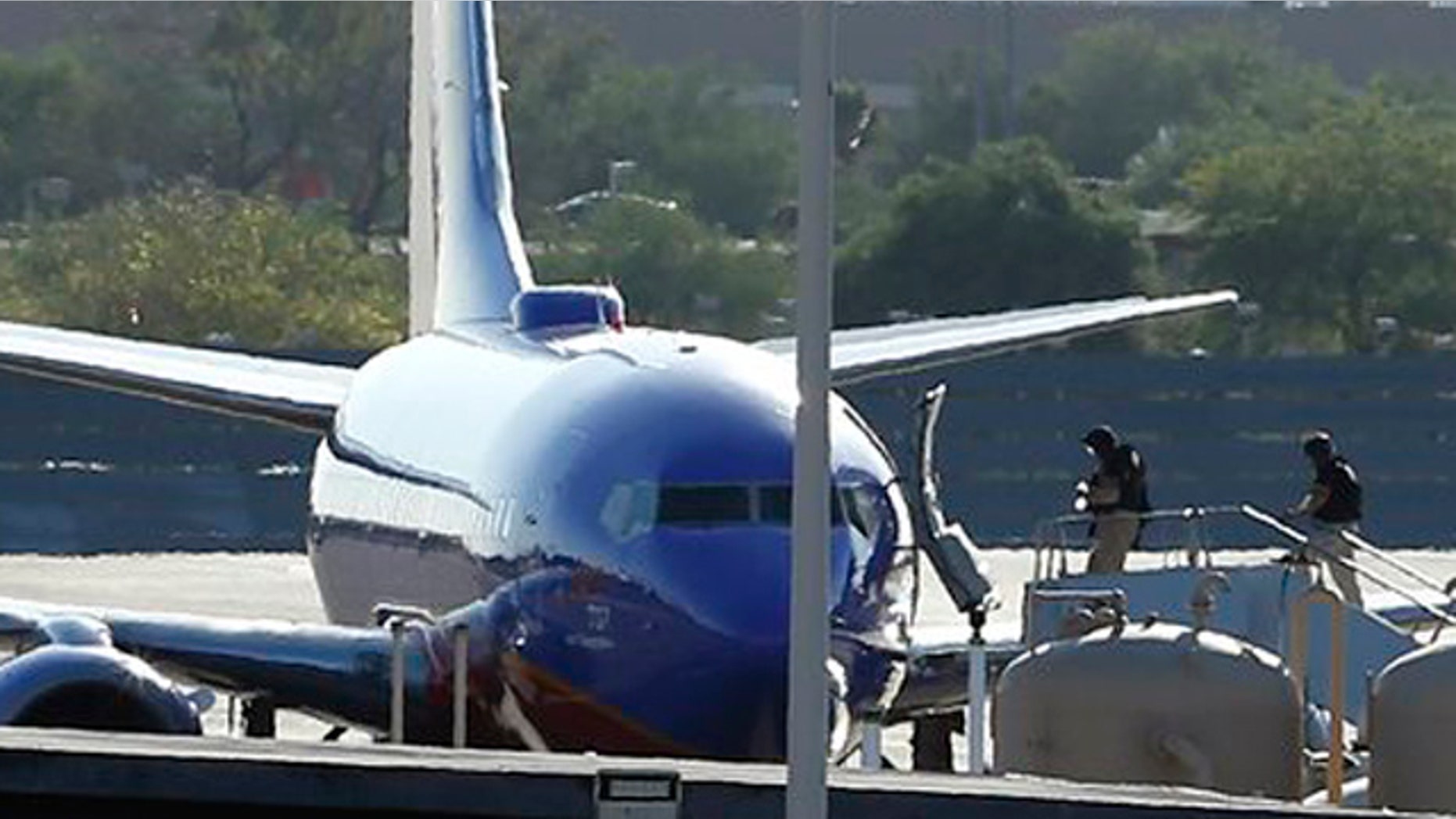 June 10, 2013: Members of the bomb squad walk onto a Southwest Airlines plane on the ground at Phoenix Sky Harbor International Airport after the FBI says a "telephonic bomb threat" against a Southwest flight from Los Angeles to Texas led to the plane being diverted to Phoenix.