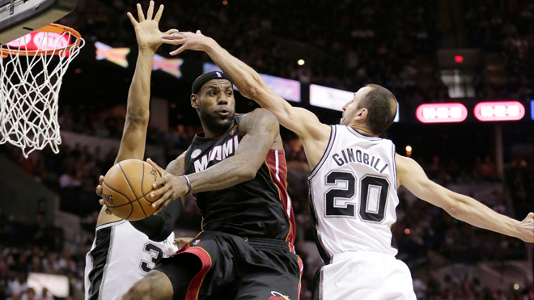 FILE - In this June 13, 2013 file photo, Miami Heat's LeBron James (6) passes between San Antonio Spurs' Boris Diaw (33), of France, and Manu Ginobili (20), of Argentina, during the second half at Game 4 of the NBA Finals, in San Antonio. A rematch of last year's thrilling NBA Finals finish is possible, but the Spurs and Heat would have to get through tough paths to get there. (AP Photo/Eric Gay, File)