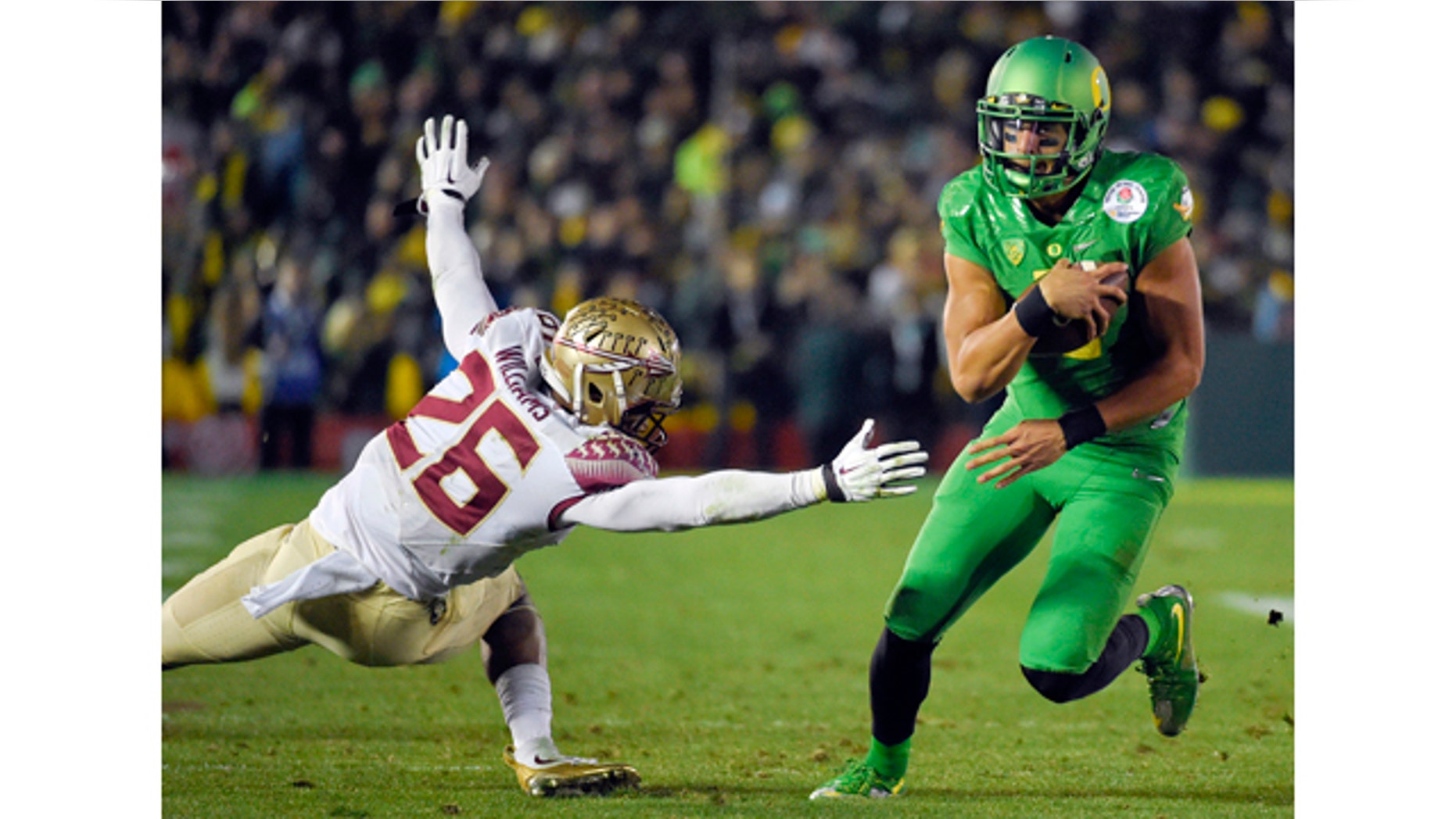 Jan. 1, 2015: Oregon quarterback Marcus Mariota, right, scores past Florida State defensive back P.J. Williams during the second half of the Rose Bowl NCAA college football playoff semifinal in Pasadena, Calif. (AP Photo/Mark J. Terrill)