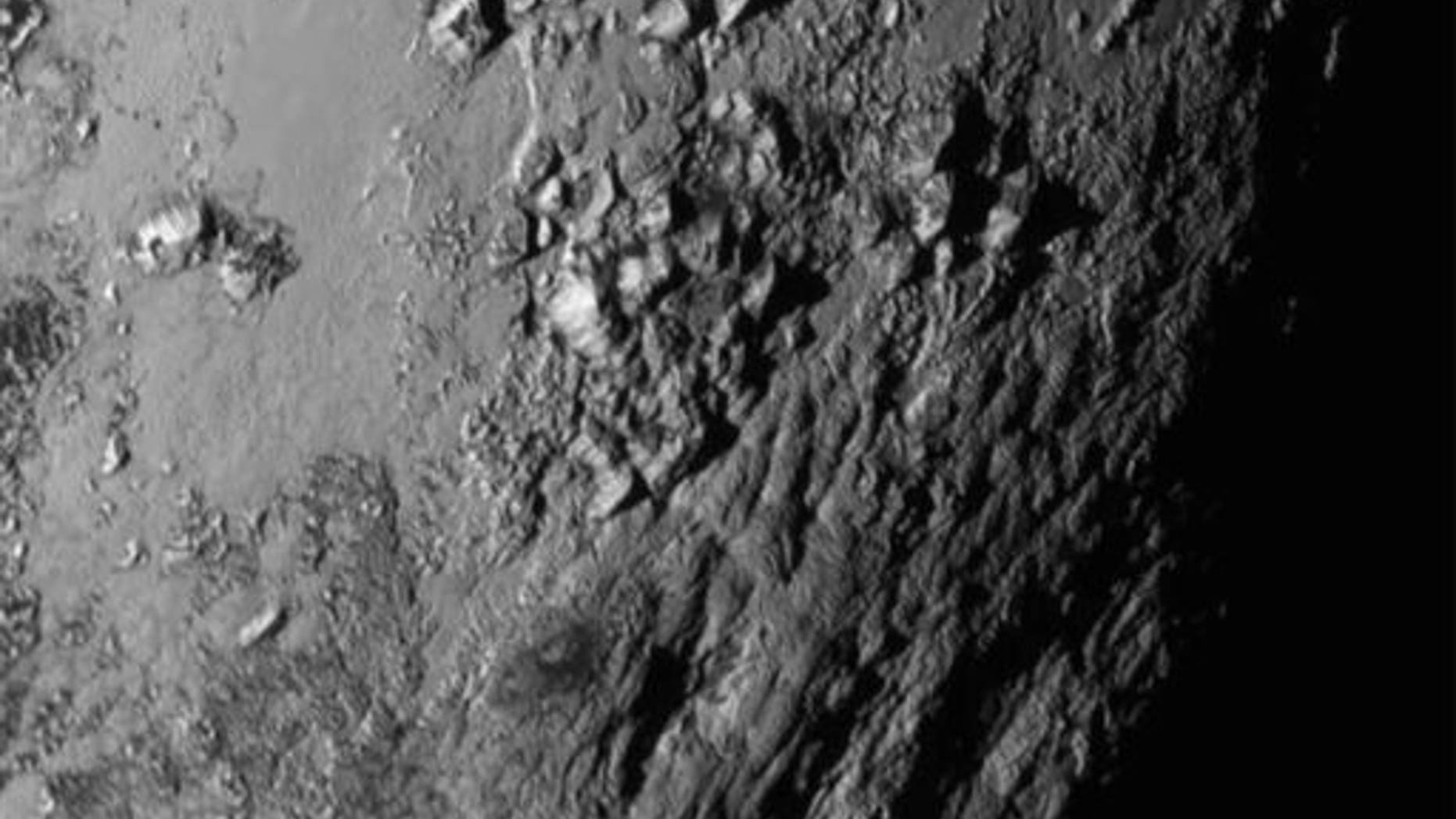 Tuesday, July 14, 2015 Image provided by NASA on Wednesday shows a region near Pluto's equator with a range of mountains captured by the New Horizons spacecraft.