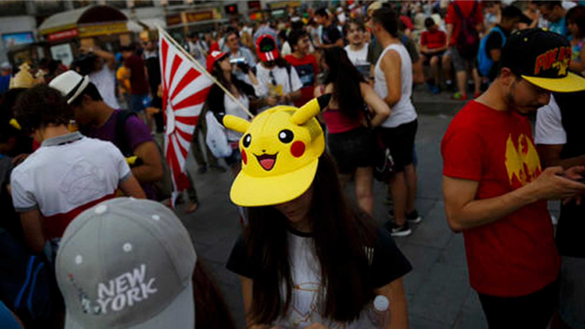 FILE - In this Thursday, July 28, 2016, file photo, fans play the highly addictive "Pokemon Go" game during a gathering in central Madrid, Spain, to play the computer game. Since debuting to wild adulation in the U.S., Australia and New Zealand this month, the game from Google spinoff Niantic Inc. has spread like wildfire, launching in more than 30 countries or territories, but not Brazil. For athletes and other visitors caught up in the wave, not having access is just one more knock against an Olympics that officials are racing to get ready. The opening ceremony takes place Friday, Aug. 5. (AP Photo/Daniel Ochoa de Olza, File)