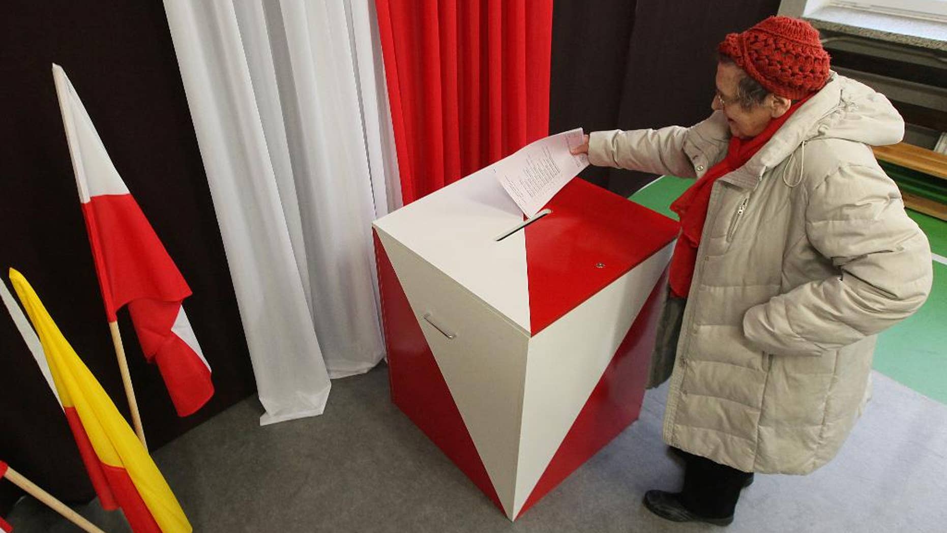 A woman casts her ballot during the first round of Polish local elections, in Warsaw, Poland, Sunday, Nov. 16, 2014. The voting is considered a test for the main parties ahead of the parliamentary elections next year. Some 30 million voters are eligible to choose nearly 47,000 councilors and 2,500 local administration leaders on Sunday, but observers are concerned about the possibility of a low turnout. Opinion polls gave a narrow lead to the governing pro-business Civic Platform party, over the nationalist opposition Law and Justice. (AP Photo/Czarek Sokolowski)