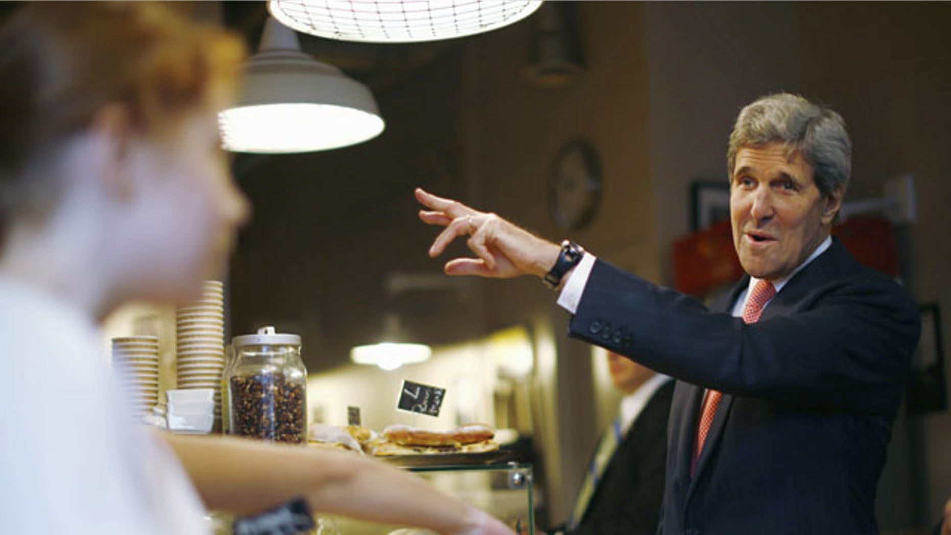 November 5, 2013: U.S. Secretary of State John Kerry buys pastries from Cafe Baguette during a walking tour of central Warsaw, Tuesday Nov. 5, 2013. Kerry is vowing that a review into NSA surveillance activities will ultimately result in the "right" balance between security and privacy and says outrage over alleged espionage and eavesdropping should not disrupt key trade talks between Europe and the United States. (AP Photo/Jason Reed, Pool)