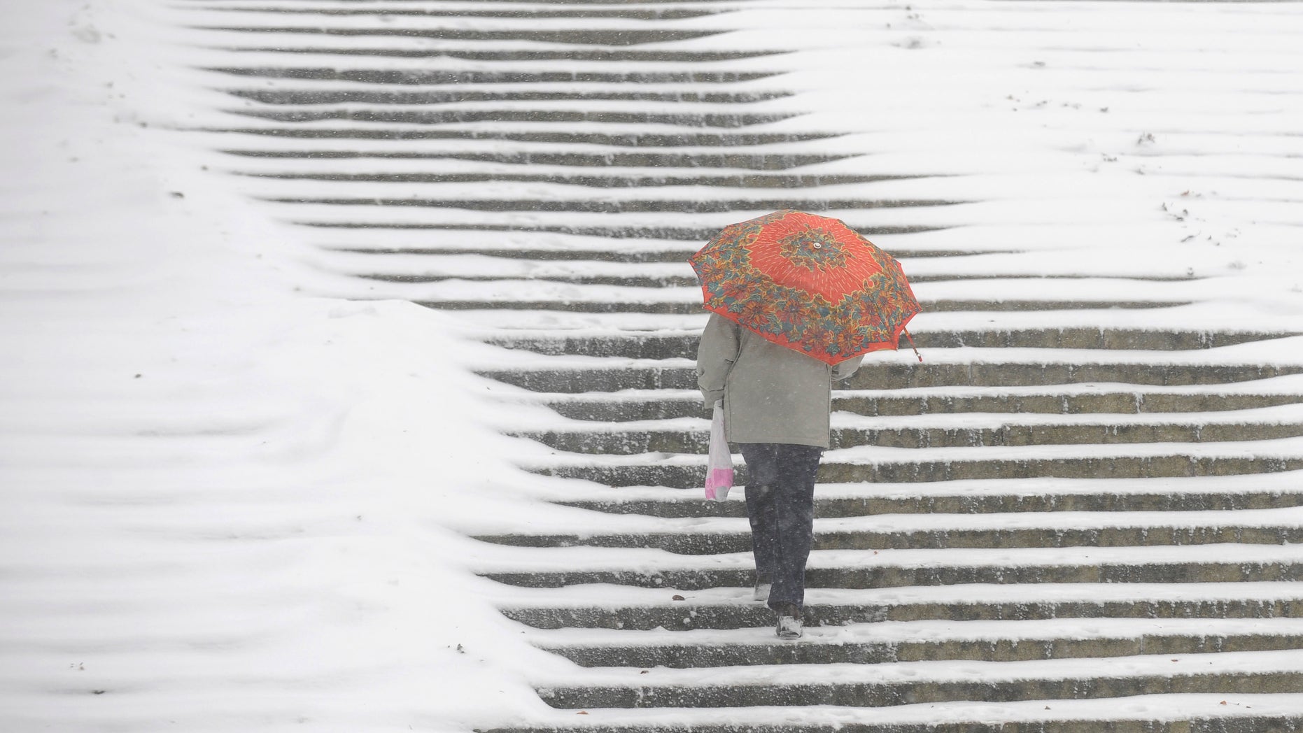 A woman walk up stairs in a park in Warsaw, Poland, Monday, Nov. 29, 2010, as first big snowfalls hit Poland this winter.
