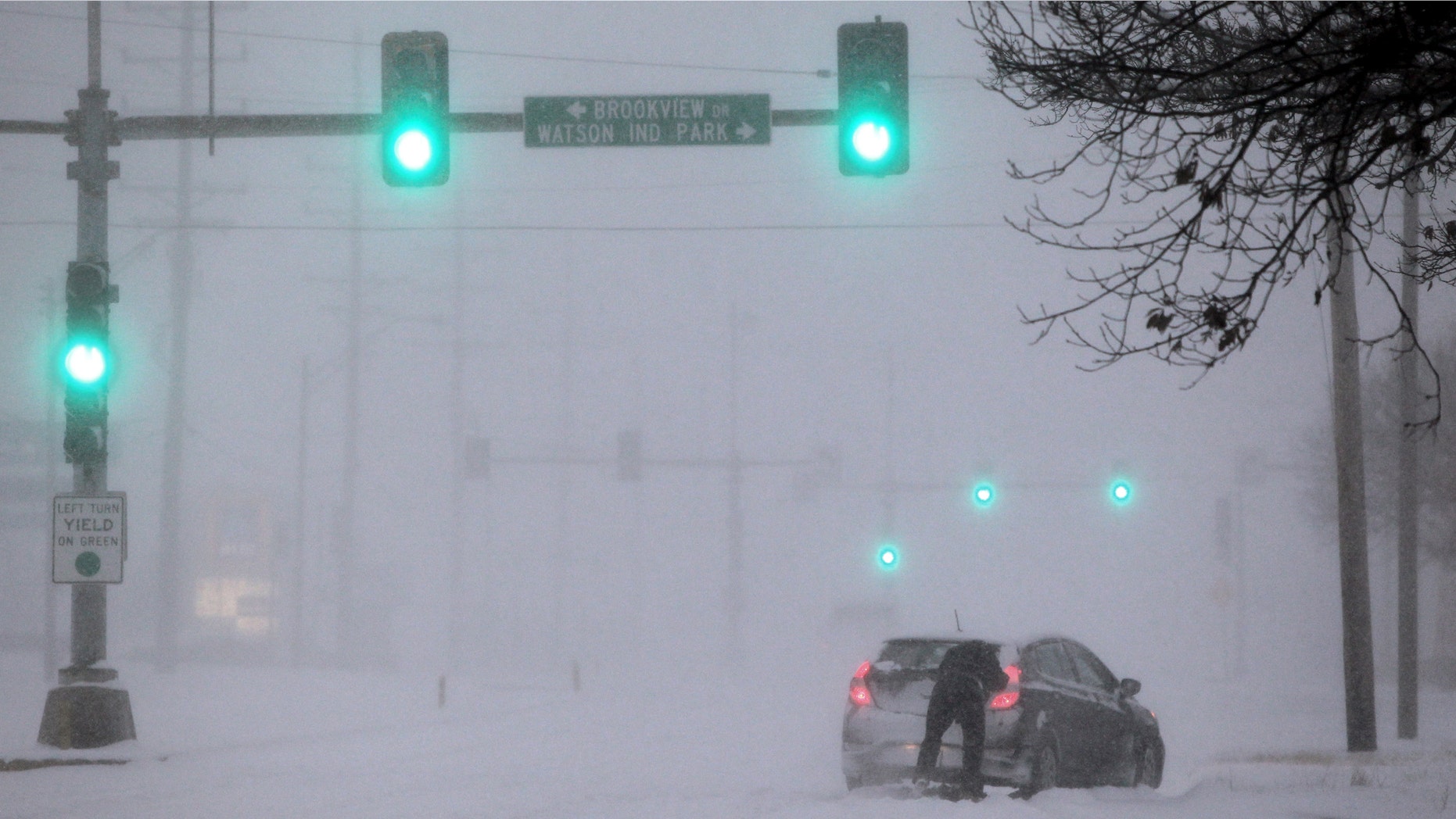 A Crestwood motorist tries to get his car moving along Watson Road in St. Louis as heavy snow falls on Sunday, Jan. 5, 2014. Snow-covered roads, high winds and ice were creating dangerous driving conditions from Missouri to Delaware on Sunday ahead of a "polar vortex" that'll bring below-zero temperatures not seen in years to much of the nation in the coming days, likely setting records. (AP Photo/St. Louis Post-Dispatch, Robert Cohen) EDWARDSVILLE INTELLIGENCER OUT; THE ALTON TELEGRAPH OUT