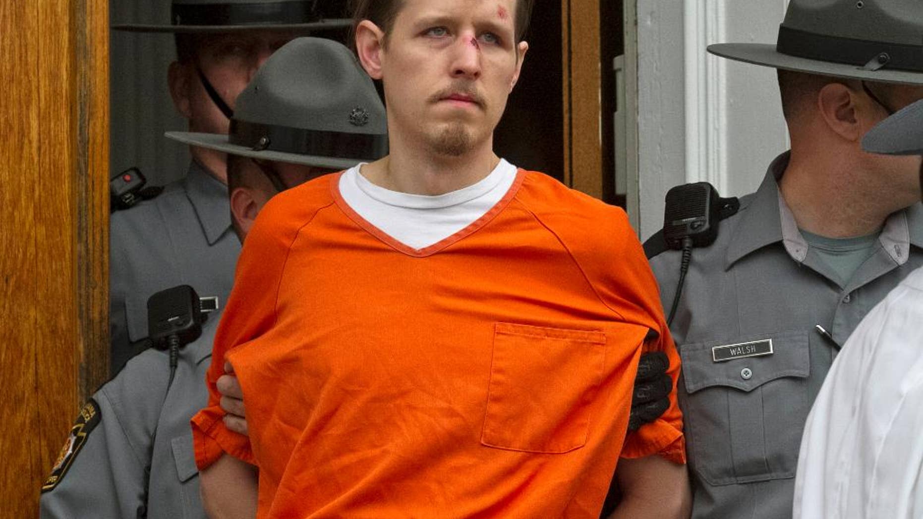 FILE - In this Oct. 31, 2014, file photo, Eric Frein, charged with the murder of Pennsylvania State Trooper Cpl. Byron Dickson and critically wounding Trooper Alex Douglass, is taken to prison after a preliminary hearing in Pike County Courthouse in Milford, Pa. On Thursday, Nov. 13, 2014, authorities added terrorism charges againstFrein and they say he told them he wanted to "wake people up." State police say Eric Frein called slaying of Cpl. Bryon Dickson an "assassination" in an interview after his capture. (AP Photo/The Scranton Times-Tribune, Michael J. Mullen, File)