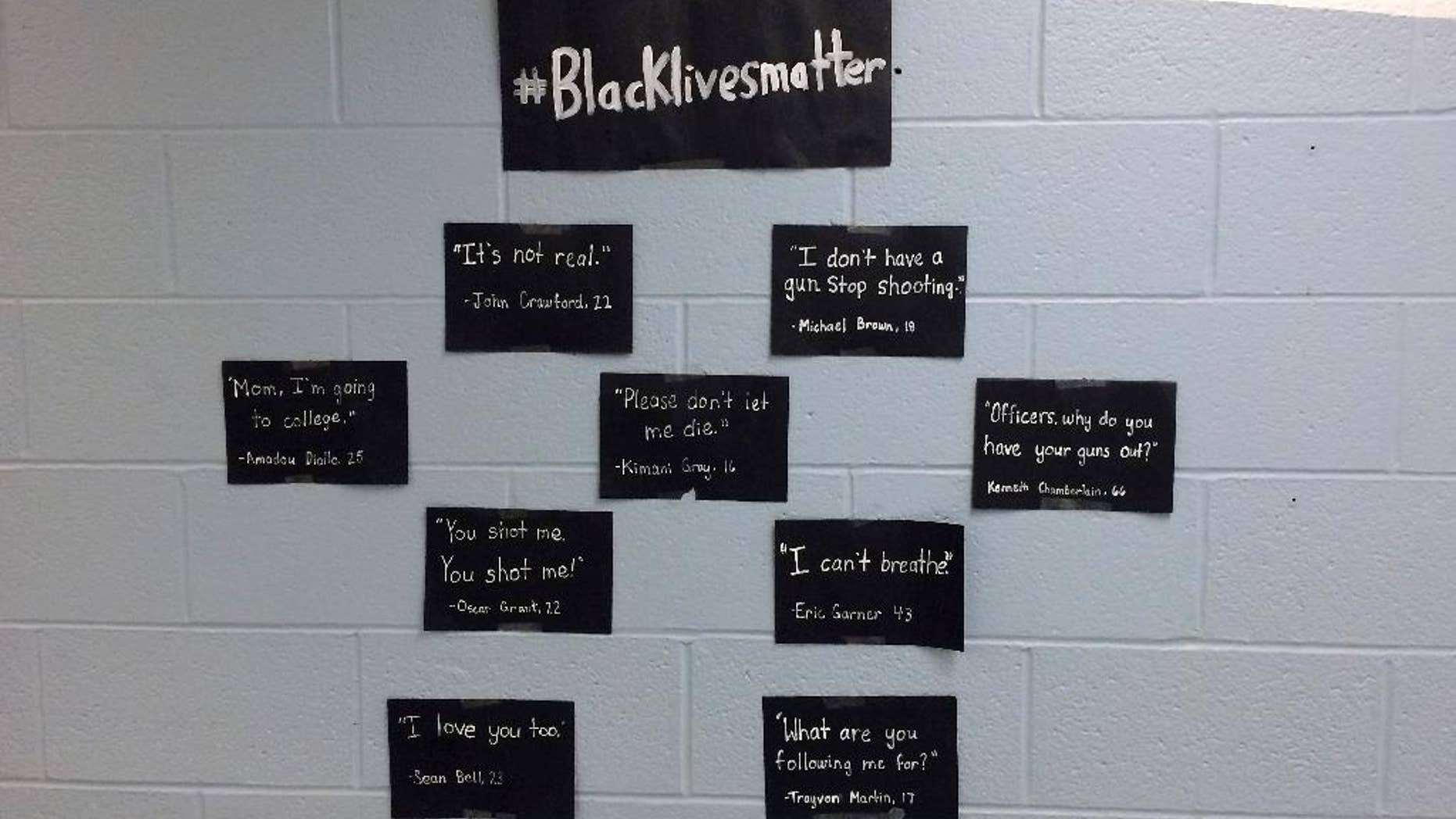 In this photo released by the Lewiston Public Schools, a display of student posters, protesting grand jury decisions not to indict two police officers who killed unarmed black men, are affixed to a wall at Lewiston High School in Lewiston, Maine, Thursday, Dec. 11, 2014. Lewiston Superintendent Bill Webster said Thursday he was allowing the display after reviewing it and meeting with students. He said students were initially required to take it down Monday because he had not had an opportunity to review it. (AP Photo/Lewiston Public Schools)