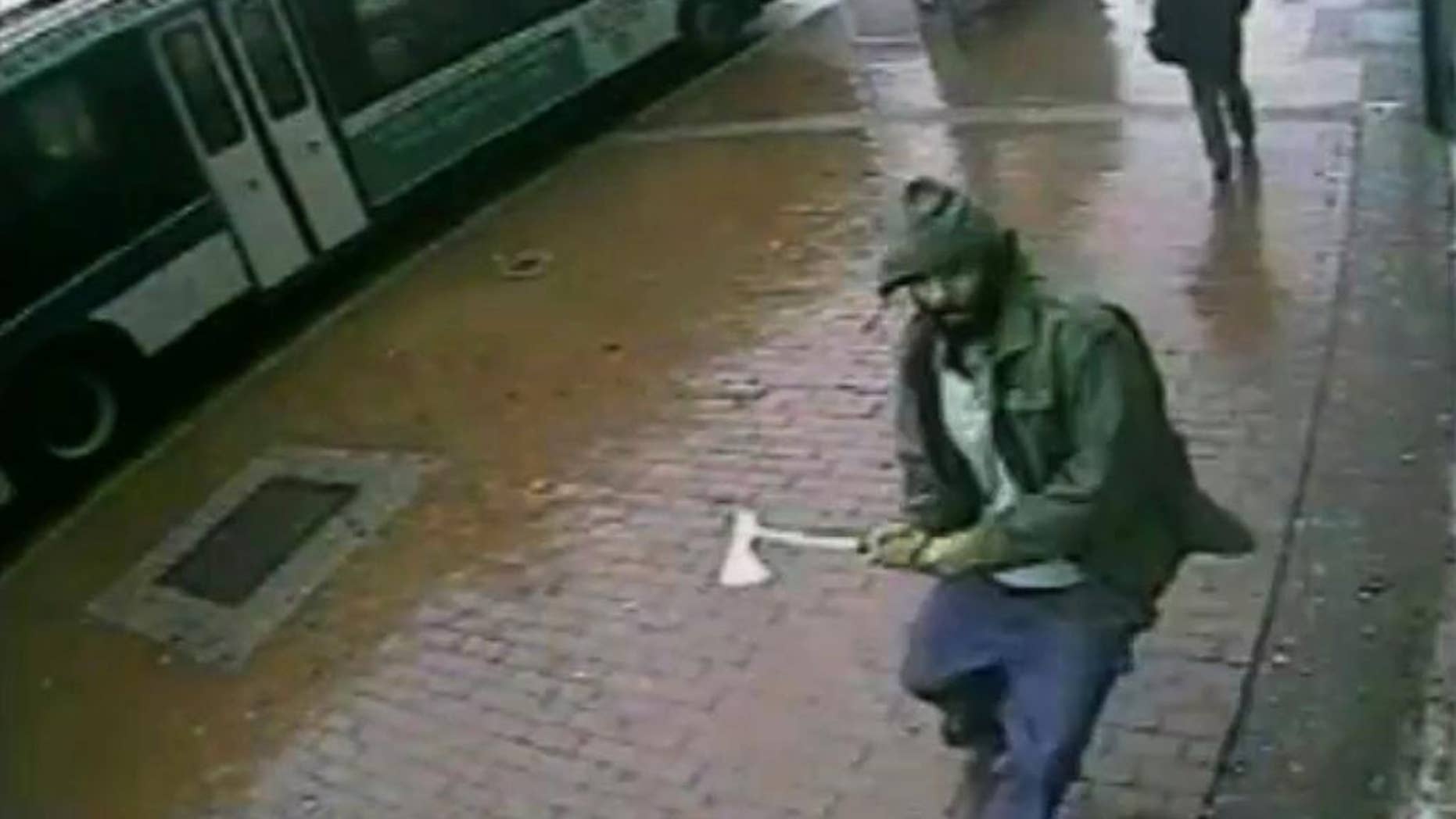 In this frame grab taken from video provided by the New York Police Department, an unidentified man approaches New York City police officers with a hatchet, Thursday, Oct. 23, 2014, in the Queens borough of New York. The man injured two with the hatchet before the other officers shot and killed him, police said. A bystander was wounded in the gunfire. Investigators were still trying to confirm the identity of the assailant and determine a motive. (AP Photo/New York Police Department)