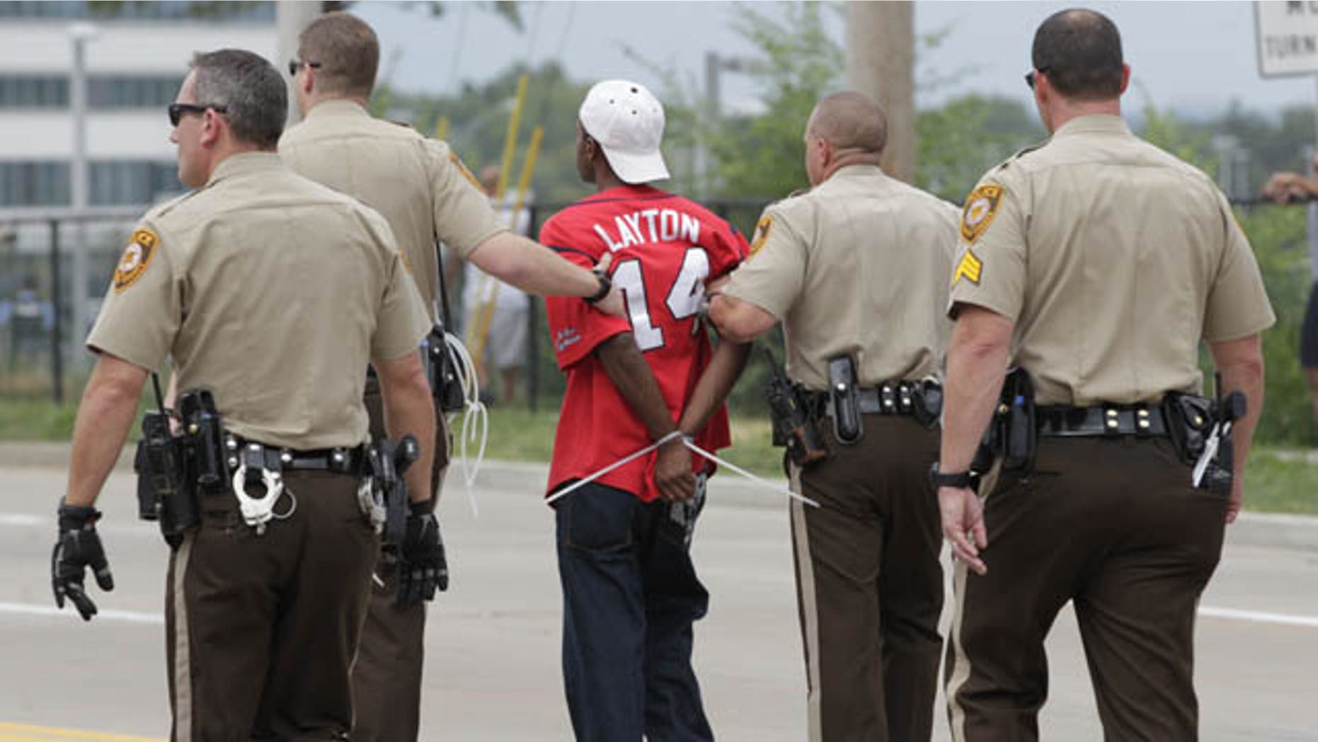September 10, 2014: Police arrest a protester after he refused to leave the area of a protest aimed at shutting down Interstate 70 in Berkeley, Mo., near the St. Louis suburb of Ferguson, Mo. where Michael Brown, an unarmed, black 18-year old was shot and killed by a white police officer on Aug. 9. (AP Photo/Tom Gannam)