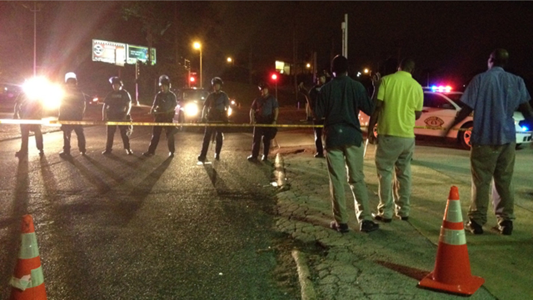 August 11, 2014: In this image made with a mobile phone, riot police line up in Ferguson, Mo. Authorities say more than 30 people have been arrested in Ferguson, where crowds have looted and burned stores, vandalized vehicles and taunted police after a vigil for an unarmed black man who was killed by police. (AP Photo/Jeff Roberson)