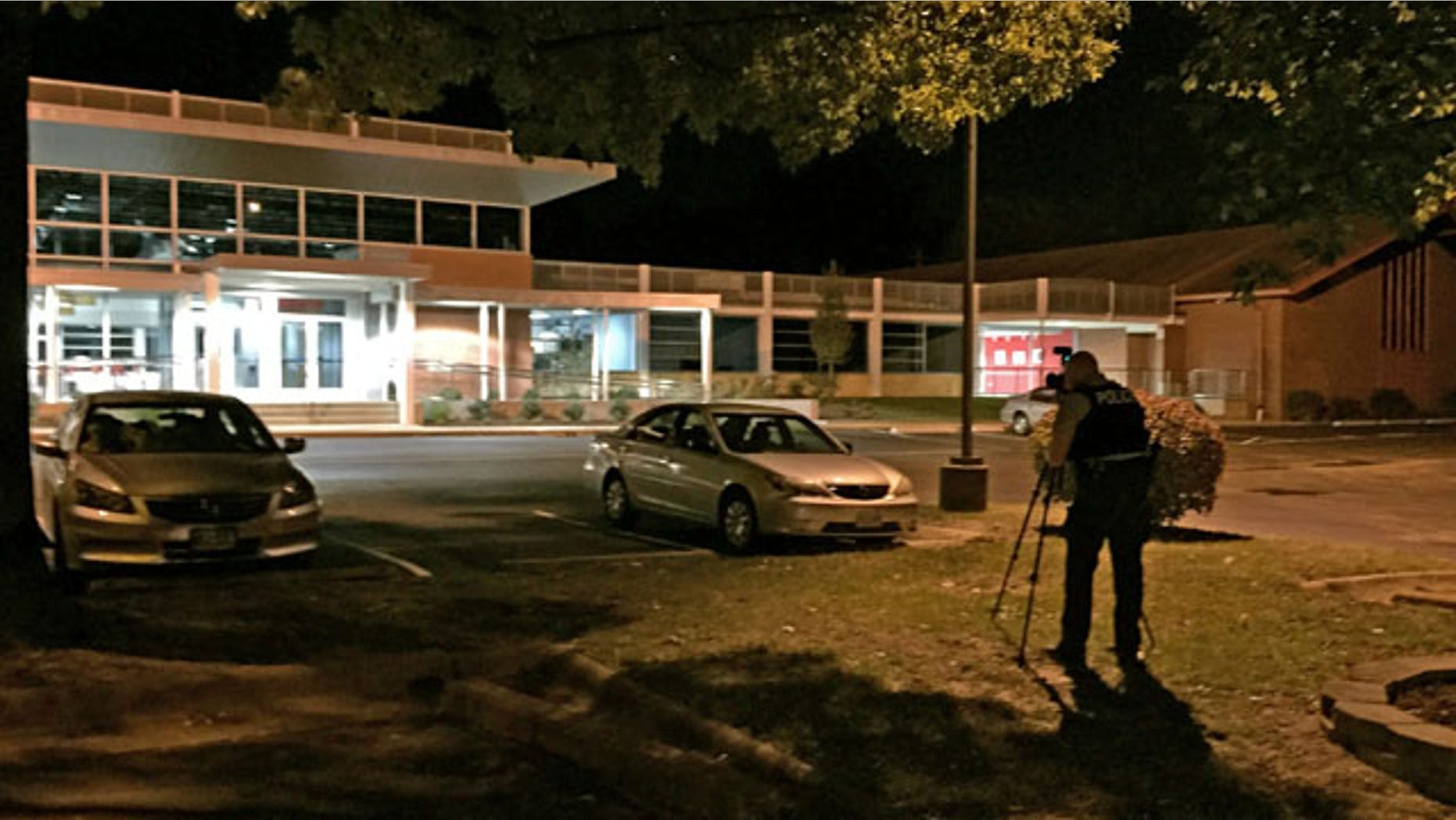 September 27, 2014: A police officer takes pictures outside the Ferguson Community Center in Ferguson, Mo. (AP Photo/St. Louis Post-Dispatch, Huy Mach).