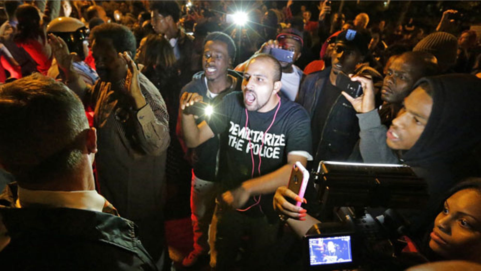 October 8, 2014: Crowds confront police near the scene in in south St. Louis where a man was fatally shot by an off-duty St. Louis police officer. St. Louis Police Lt. Col. Alfred Adkins said the 32-year-old officer was working a secondary security job late Wednesday when the shooting happened. (AP Photo/St. Louis Post-Dispatch, David Carson)
