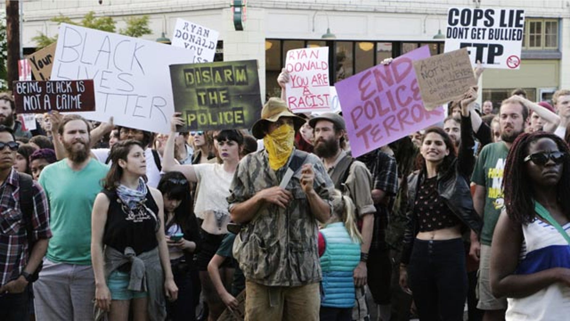 May 21, 2015: Hundreds of people protesting a police shooting gather outside of City Hall in Olympia, Wash. Police say that two stepbrothers suspected of trying to steal beer from a grocery store were unarmed when they were shot by an officer who later confronted them. (AP Photo/Rachel La Corte)
