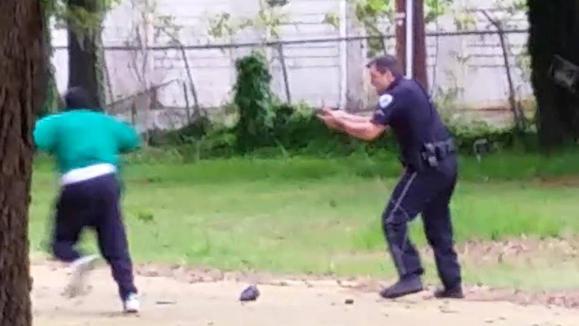 FILE - In this April 4, 2015, file photo, from video provided by Attorney L. Chris Stewart representing the family of Walter Lamer Scott, Scott appears to be running away from City Patrolman Michael Thomas Slager, right, in North Charleston, S.C. Slager was charged with murder on Tuesday, April 7, hours after law enforcement officials viewed the dramatic video that appears to show him shooting a fleeing Scott several times in the back. (AP Photo/Courtesy of L. Chris Stewart, File)